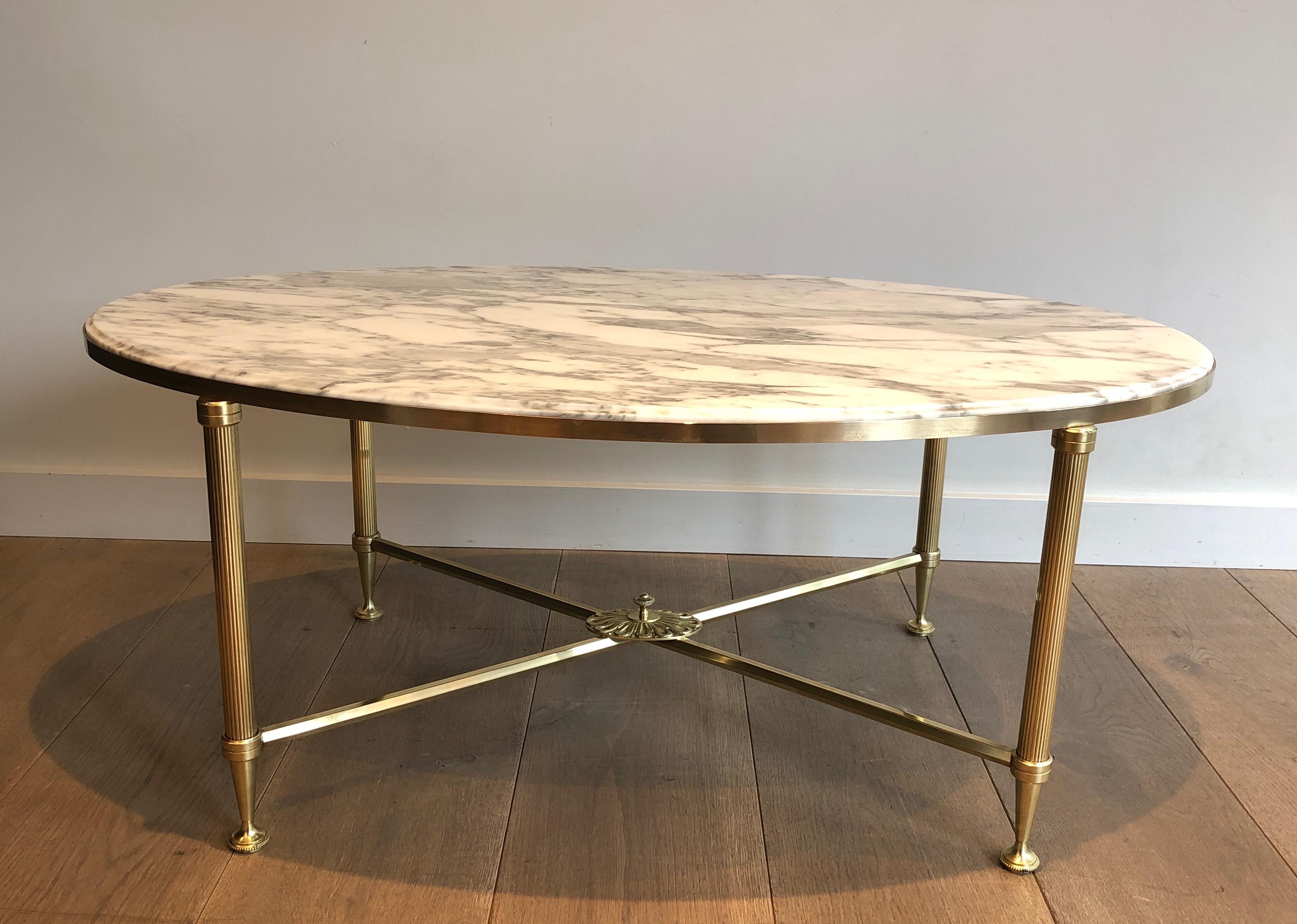 This rare neoclassical style oval coffee table is made of brass with a Carrara white marble top. This is a very nice and unusual model in this oval shape. This is a French work by Maison Jansen. Circa 1940