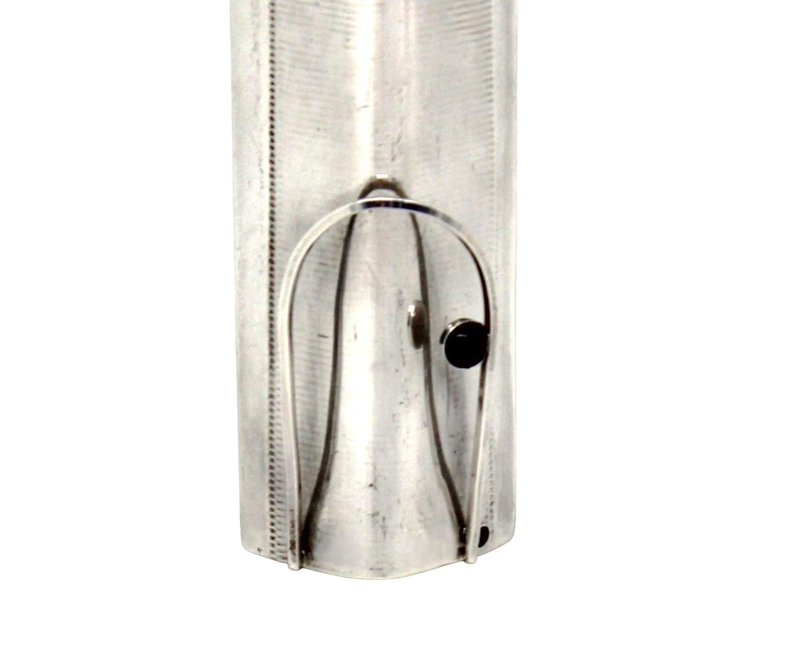 Questa straordinaria Mezuzah di grandi dimensioni è un esempio raro e sorprendente di Judaica contemporanea, realizzata in argento e ottone. Con un'impressionante lunghezza di 24 centimetri e una larghezza di 4 centimetri, questo Mezuzah incarna un