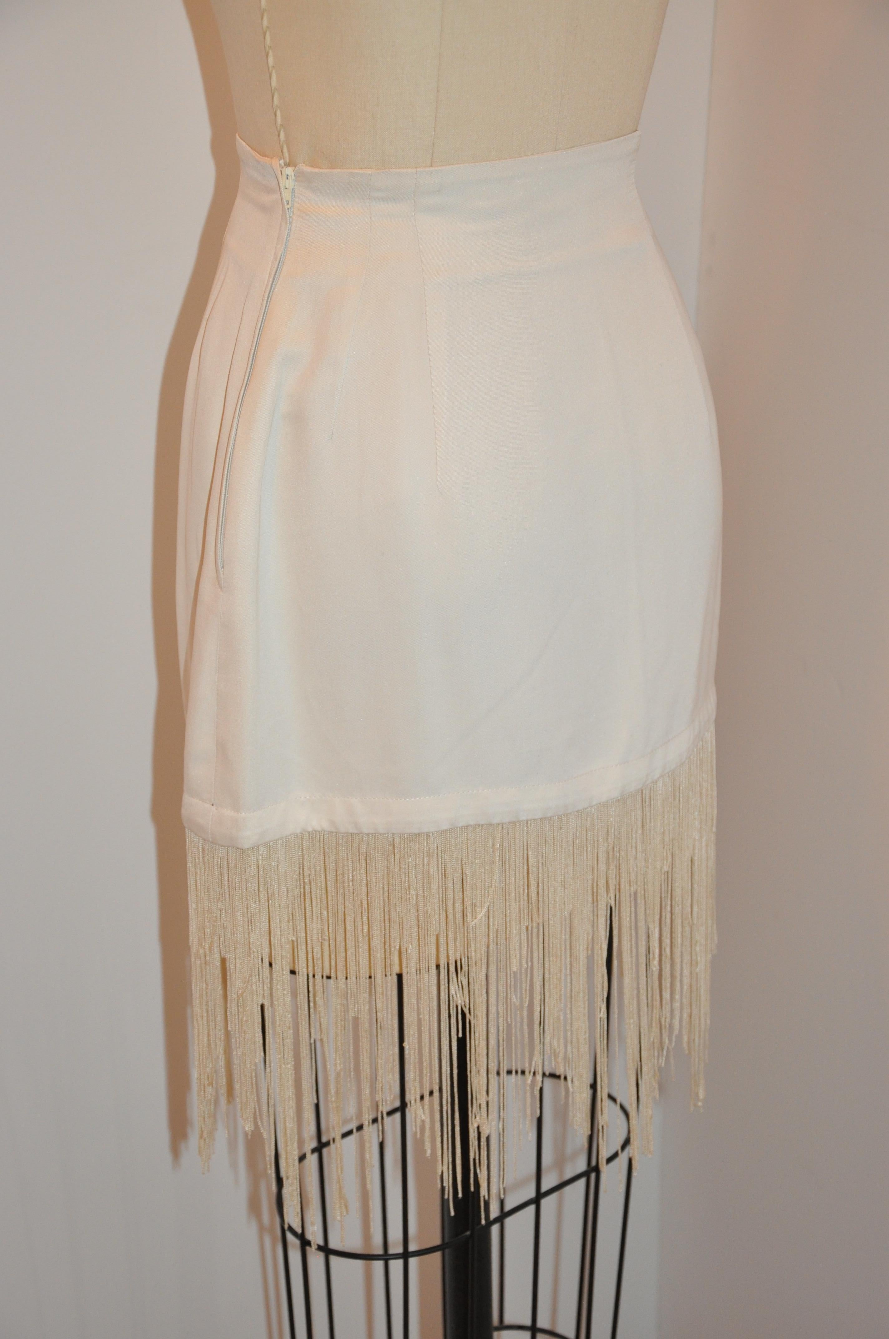 Rare Ozbek whimsical cream 2-piece cream silk mini skirt with multi-length fringes measures 13 1/2 inches (without fringe) in length. fringes are 9 inches, side zipper is 8 inches, waist is 25 inches, hem is 38 inches, hips are 38 inches.
The blazer