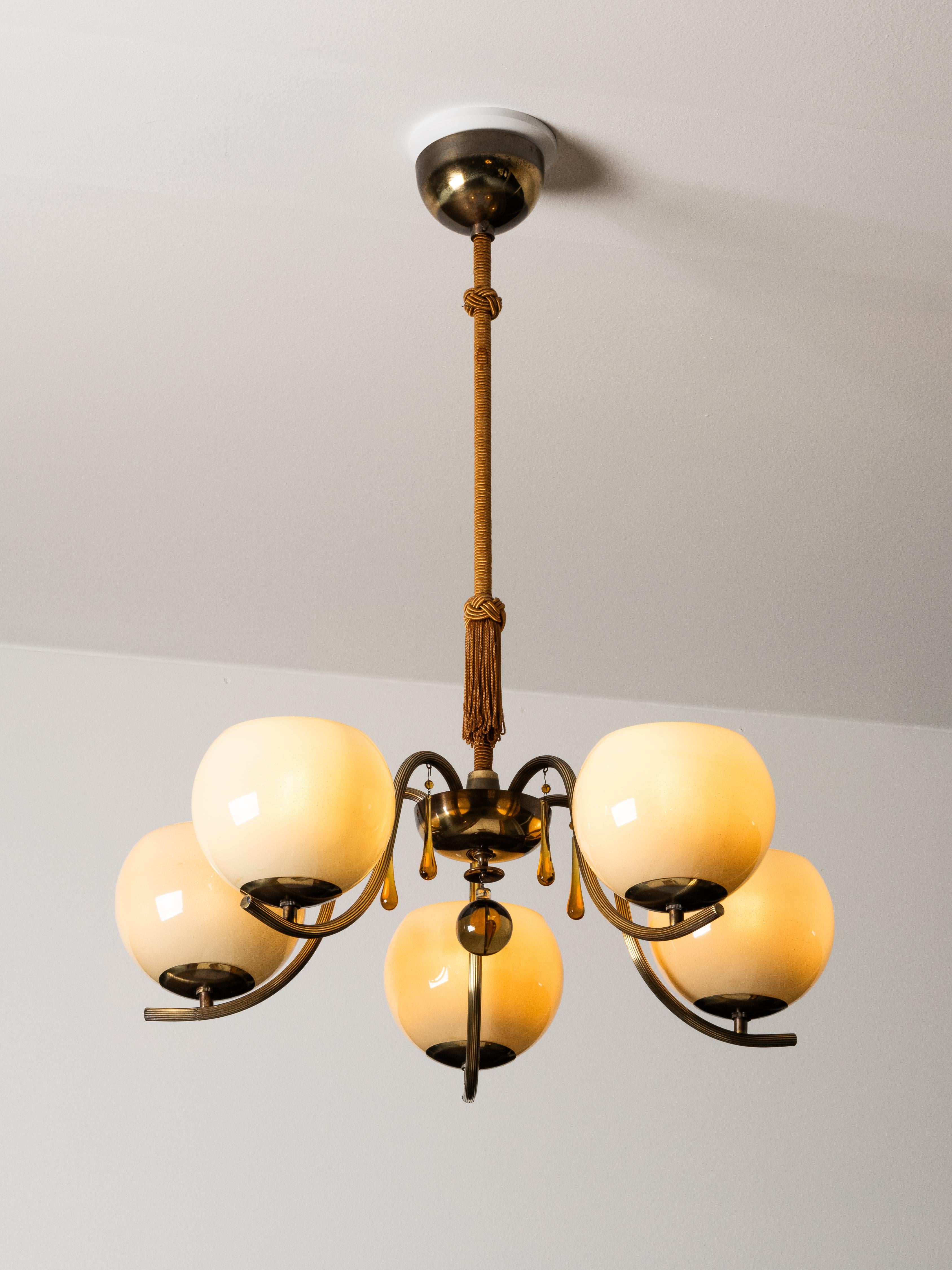 A beautifully preserved early chandelier by Paavo Tynell, Model 1456/5, produced by Taito Oy in the 1930s. This exceptional piece highlights Tynell’s signature fusion of elegance and craftsmanship, combining warm brass tones with softly tinted glass