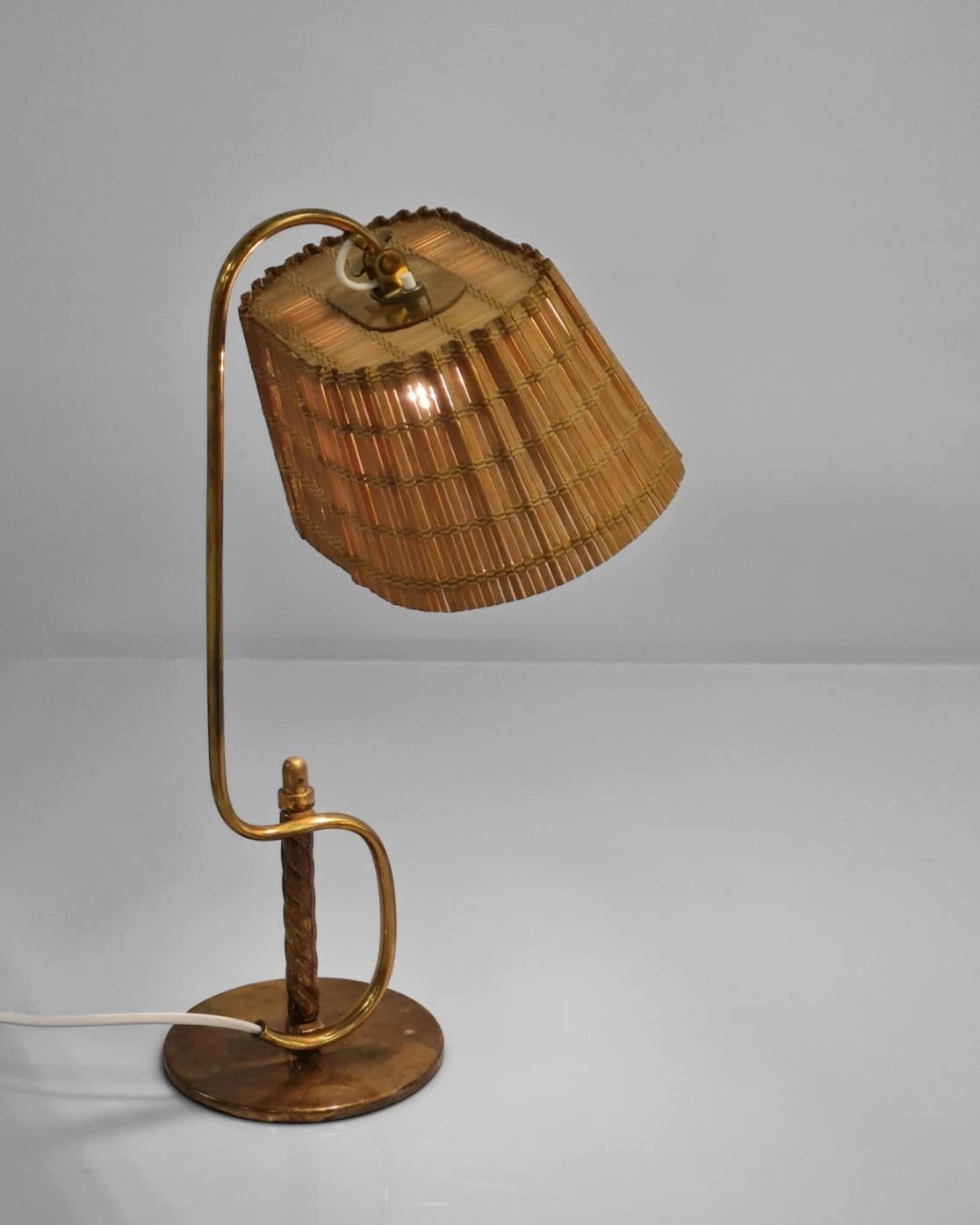 An unbelievably beautiful table lamp by the master of lightings design Paavo Tynell. This lamp is not only sleek, and very different than the other standard Tynell table lamps, it is very rare, even possibly unique with the brass handle, as it