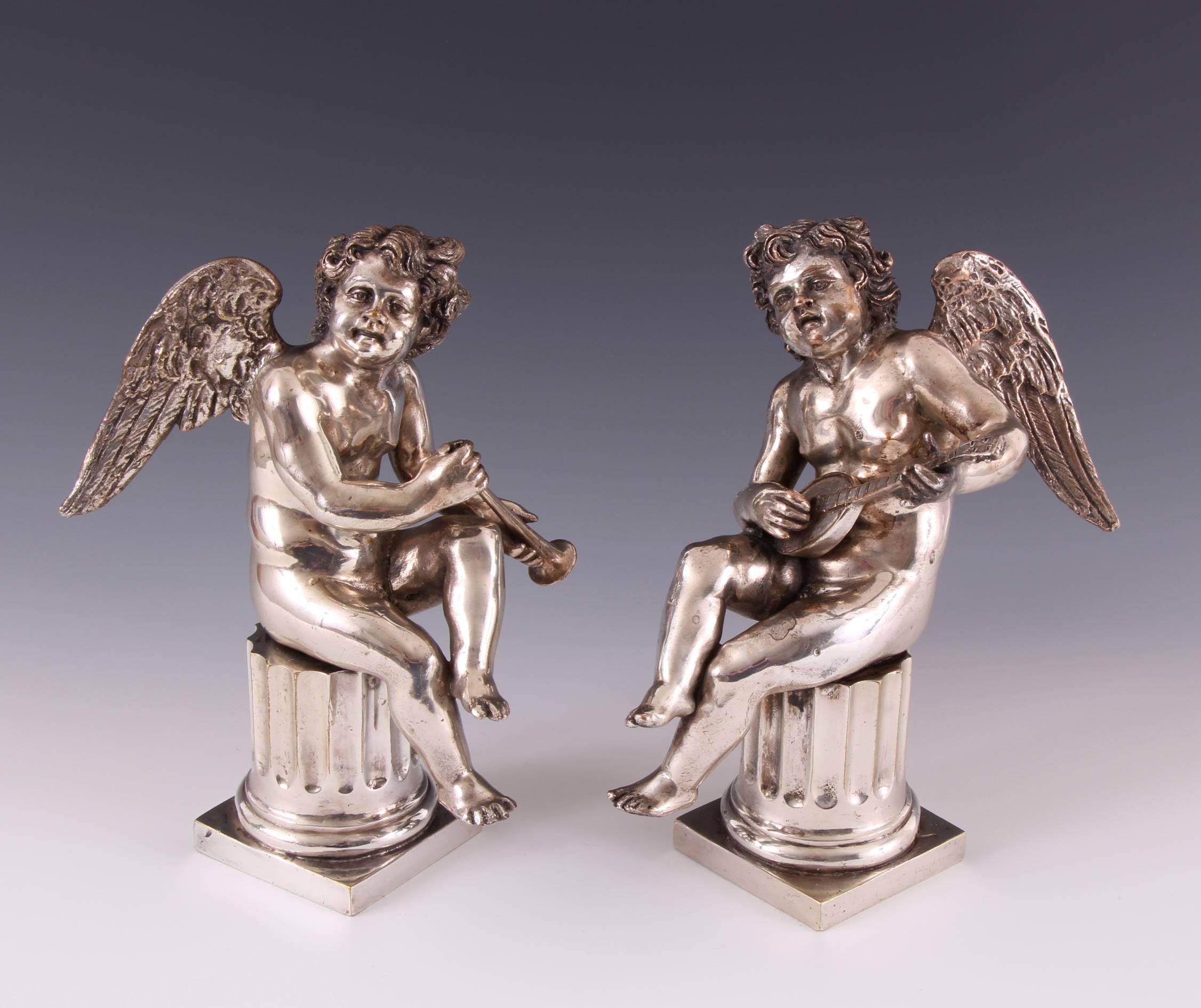 Beautiful pair of 18th century Louis XV silvered bronze musical cherubs on columns. The silvering on these delightful and elegantly sculpted pair exhibits the most wonderful aged color and patina. Each cherub sitting atop a fluted column playing