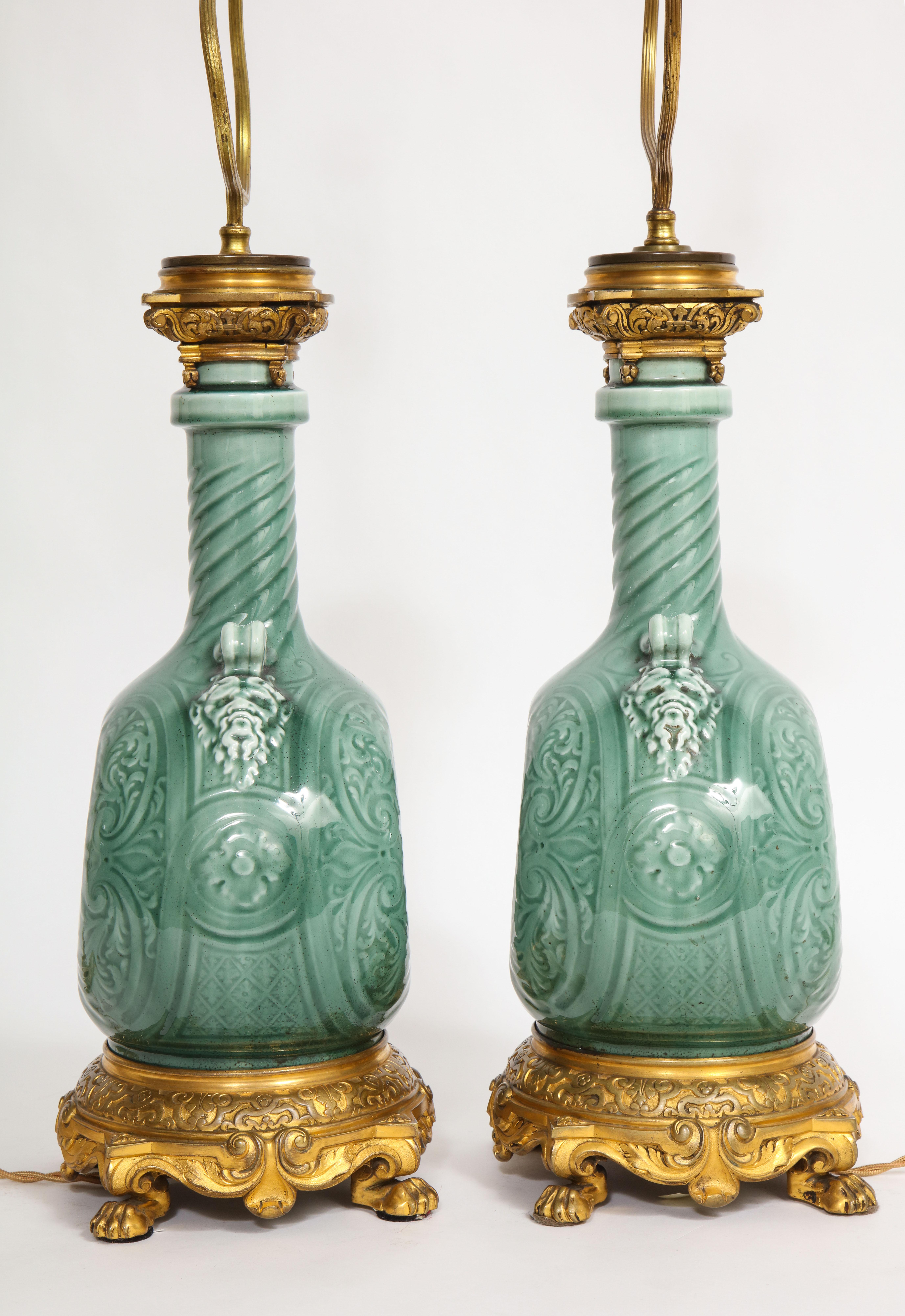 A Rare Pair of 19th Century French Ormolu Mounted Signed Theodore Deck Faience Porcelain Vases Mounted to Lamps. The porcelain bodies have a flattened, circular form with a slightly convex profile. The surface is covered in a turquoise/green glaze