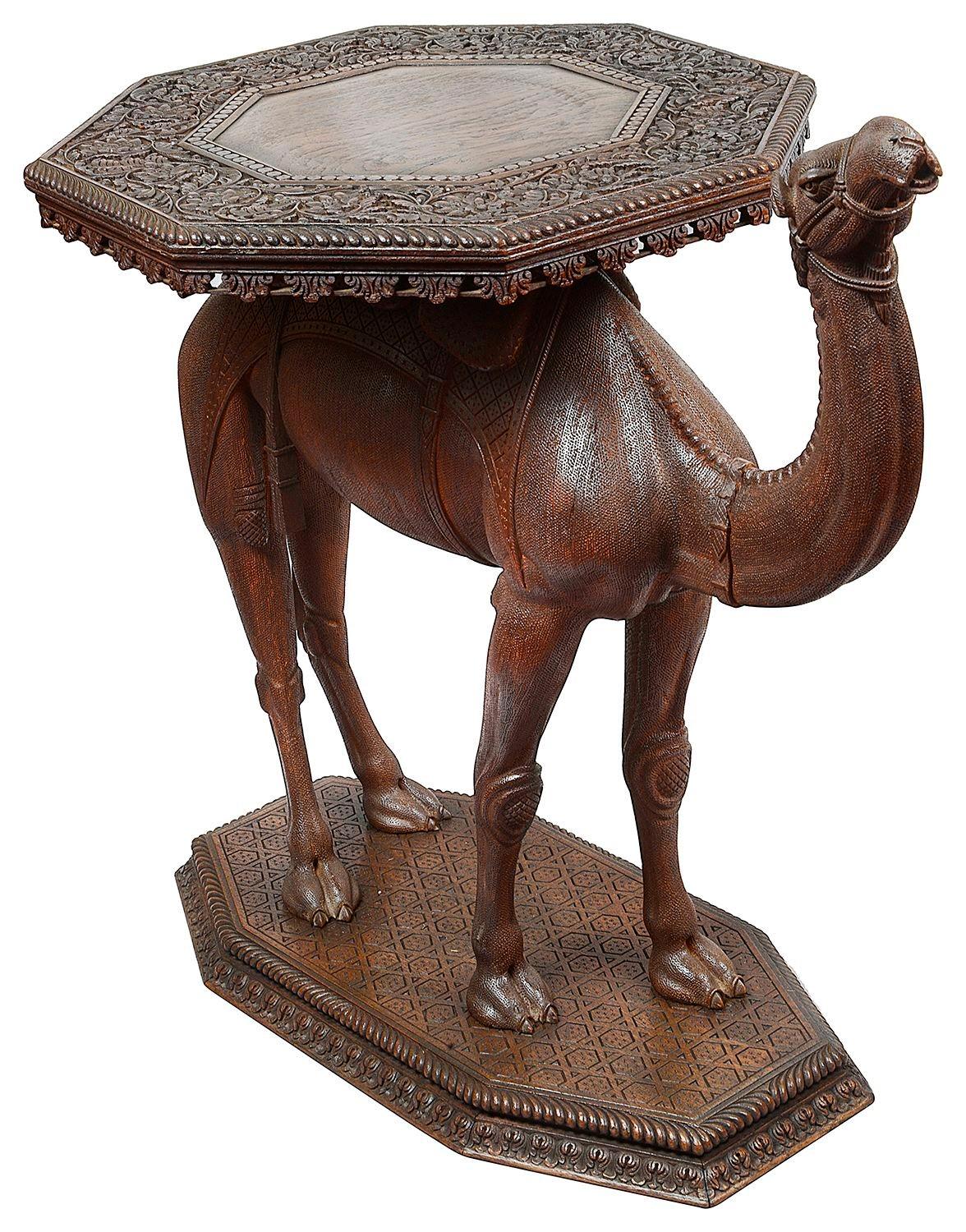 Rarísima pareja de mesas auxiliares de teca tallada a mano en forma de camello de la India. Cada una tiene la parte superior octogonal con decoración foliada finamente tallada.

Lote 80 c/c 62475 SSKZN + 62865 UHYZN +JS