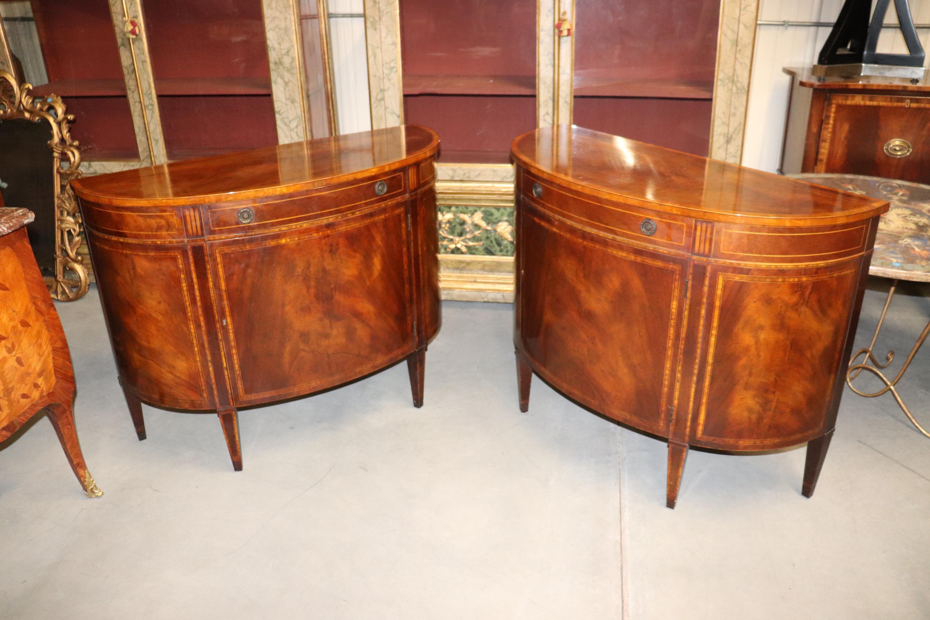 This is a superb pair of flame mahogany buffets designed in the Sheraton style and done with outrageous flame mahogany. The wood quality is absolutely incredible. The condition is very good for their age and while one buffet does have some very