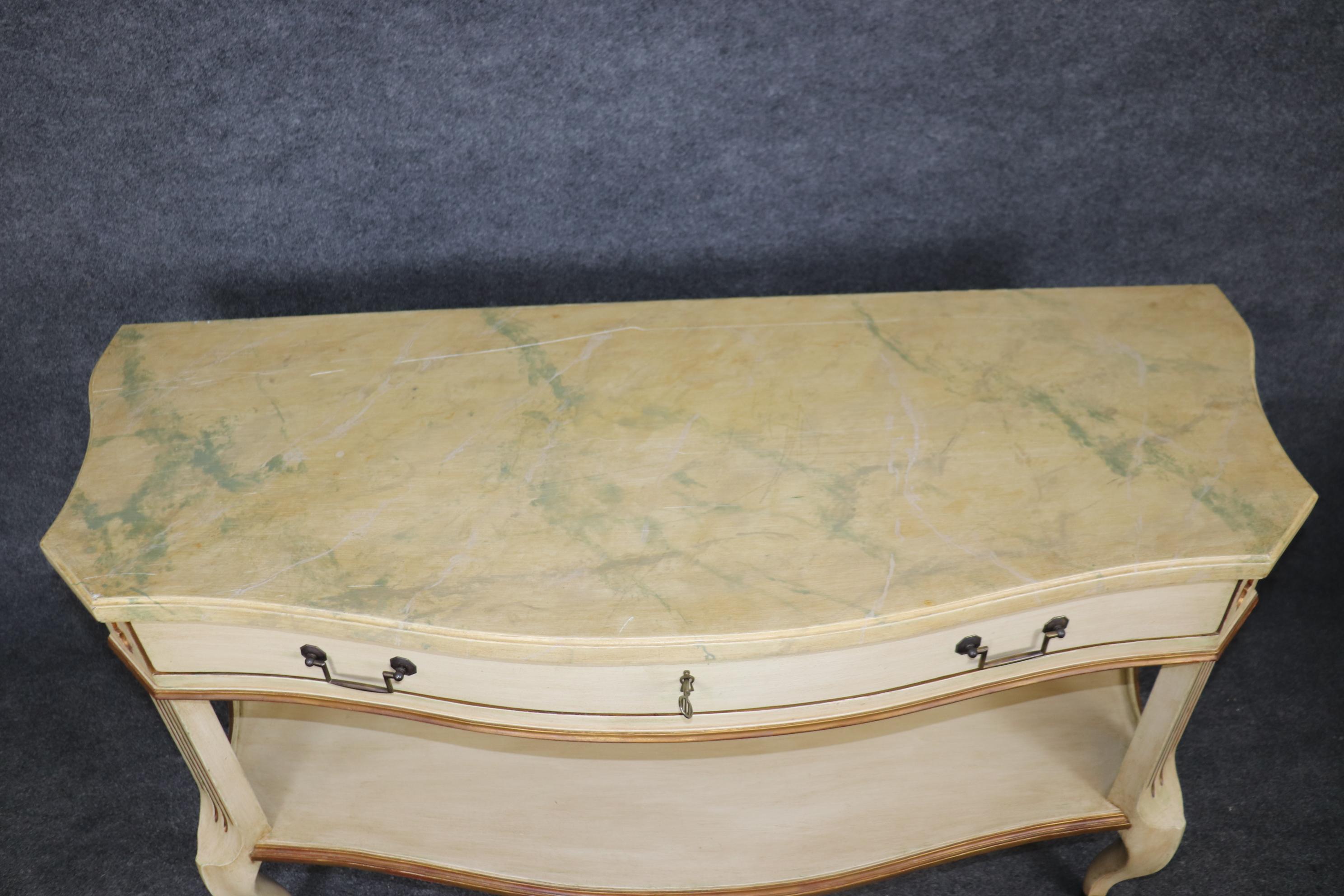 This is a superb pair of unique painted console tables. Designed in the Regency style, the consoles feature mirror surfaces in the middle and faux marble paint decorated tops that are superbly done. The consoles are in good condition and will show
