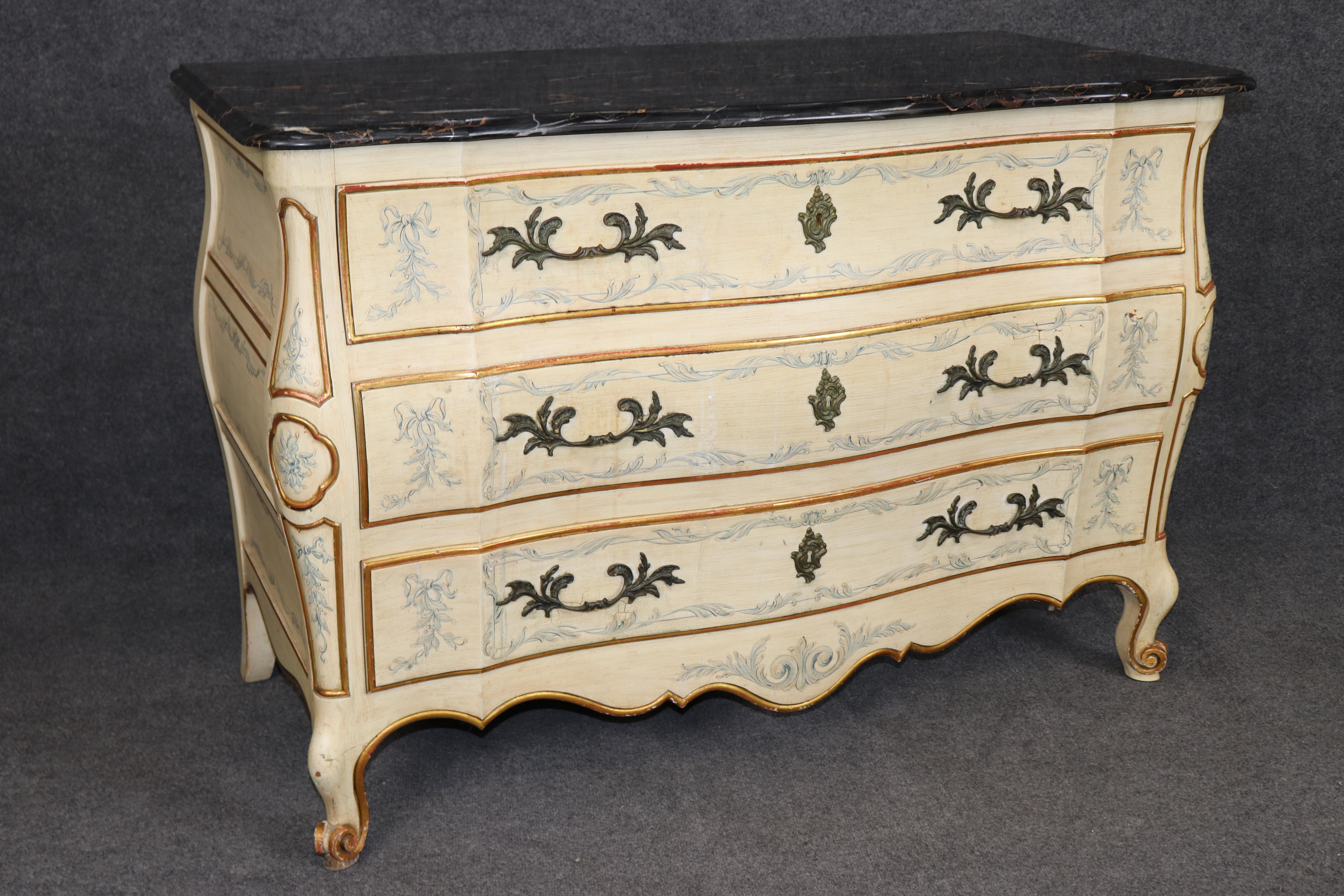 This rare pair of John Widdicomb Venetian style paint-decorated marble top commodes represents the pinnacle of refined American craftsmanship inspired by European tradition. Each dresser features a gracefully serpentine bombe form with hand-painted
