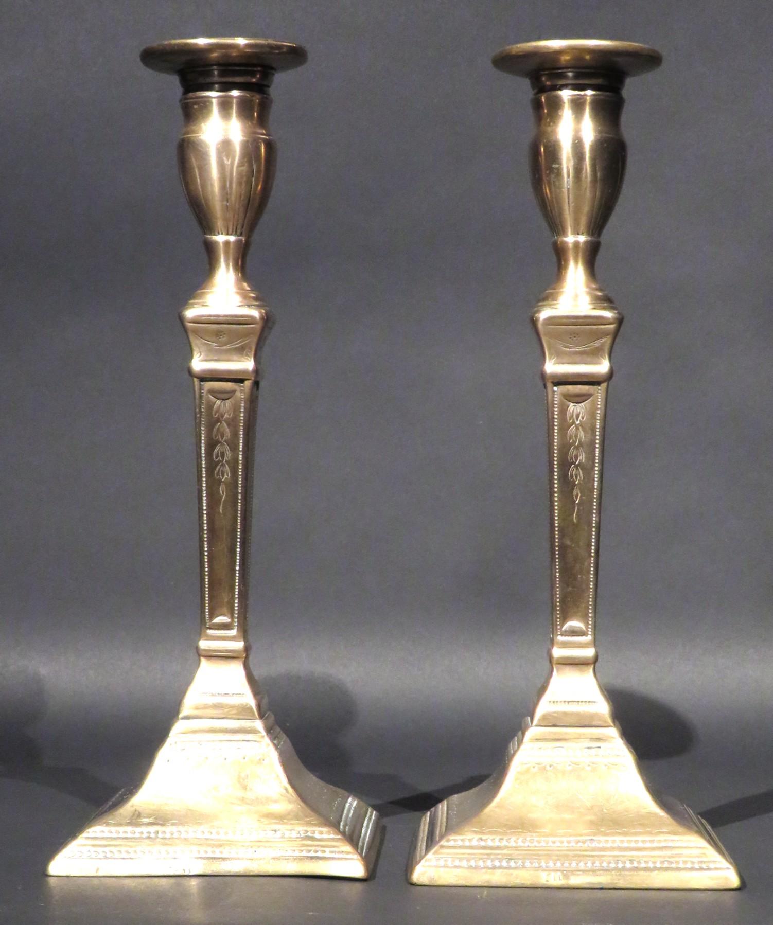 A very rare pair of 18th century neoclassical bell-metal candlesticks fitted with a unique candle gripping mechanism developed & patented by James Tate of Birmingham in 1775. Both showing flaring squared columns with hand embossed honeysuckle