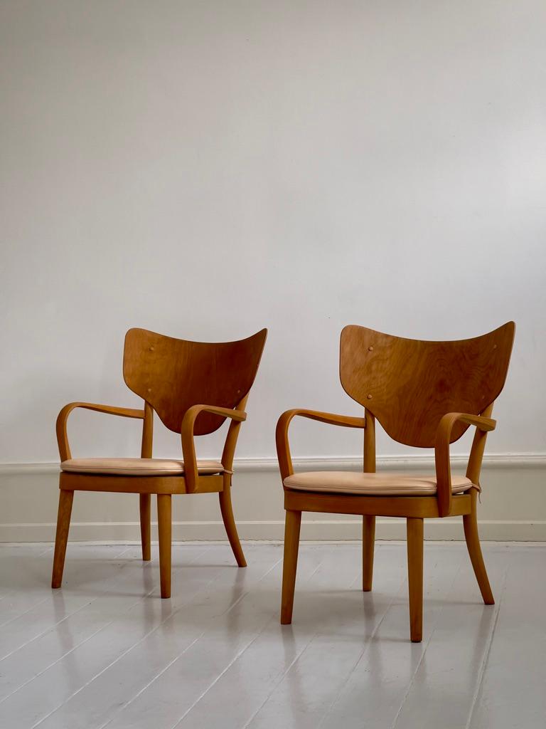 Esta rara pareja de sillones modernos daneses, diseñados en la década de 1930 por el arquitecto Magnus Læssøe Stephensen para el estimado ebanista Fritz Hansen, ejemplifica el espíritu innovador del primer modernismo danés. Fabricados en madera de