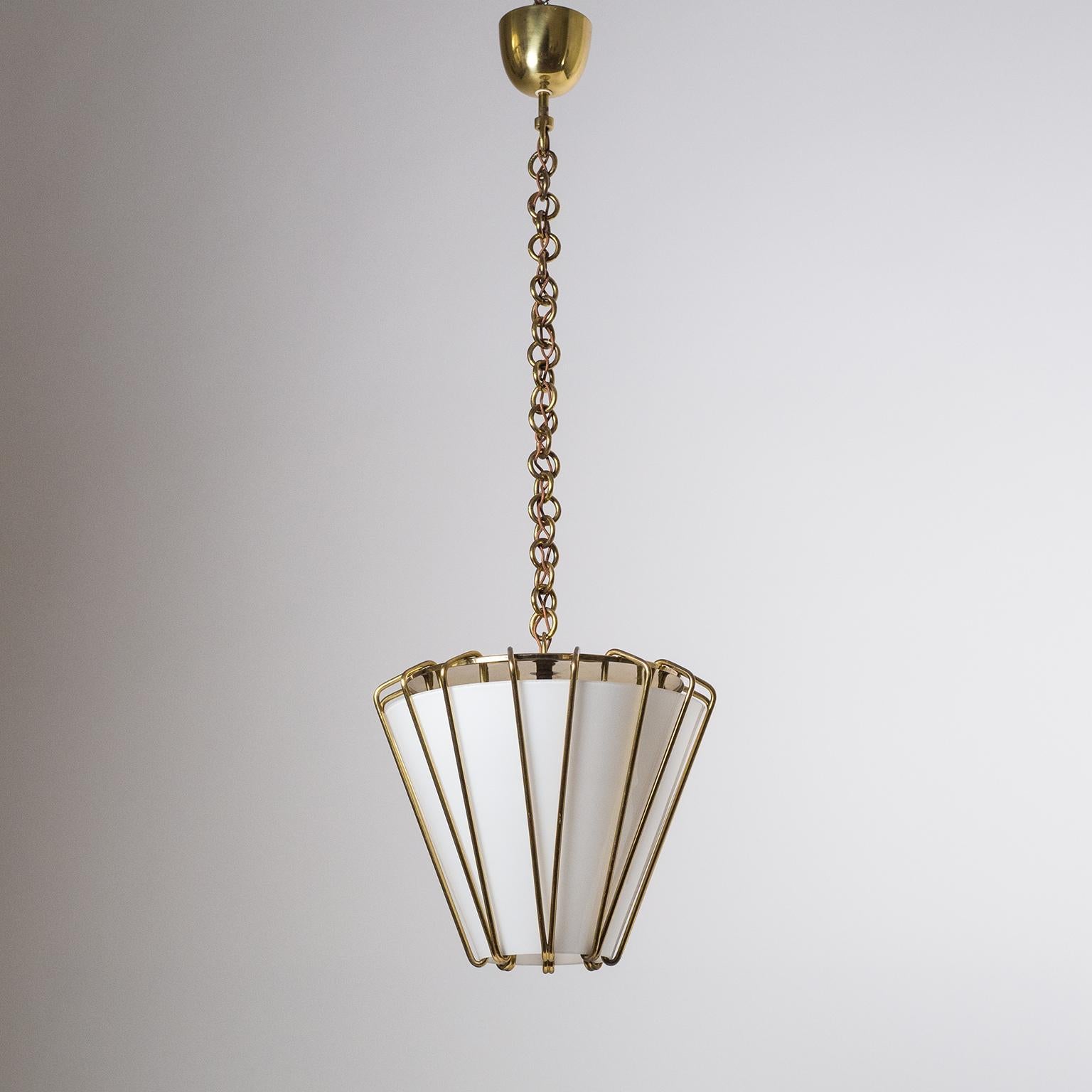 Rare pair of J.T. Kalmar pendants or lanterns from the 1940s in brass and glass. The large conical glass diffusers are suspended by an ingenious design of thick brass wires. Very nice original condition with some patina to the brass, most notably on
