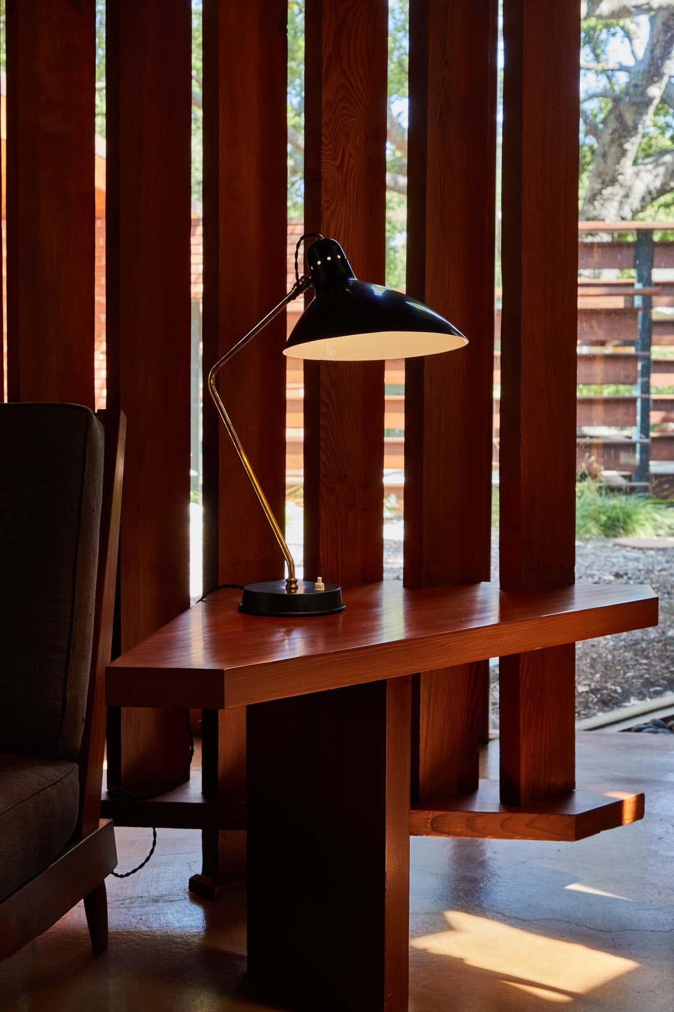 Pair of 1950s Boris Lacroix table lamps. This rare and elegant table lamp is executed in black metal and brass, France, circa 1950s. Shade rotates freely on brass ball joint for high adjustability. A celebrated Art Deco lighting designer who