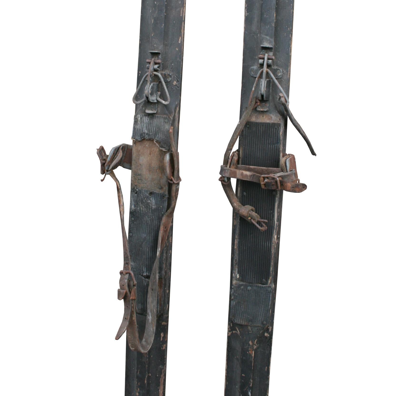 Pair of early Scandinavian Skis, most probably made for cross country purpose. The ski's have the unusual wide groove on the bottom and a early type binding that is fitted through the ski. The front part of the binding may well be a later addition.