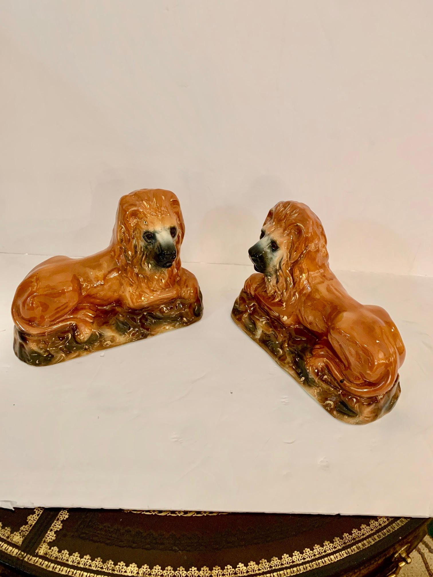 Beautiful collectible pair antique Staffordshire 19th century reclining lions with glass eyes.
  