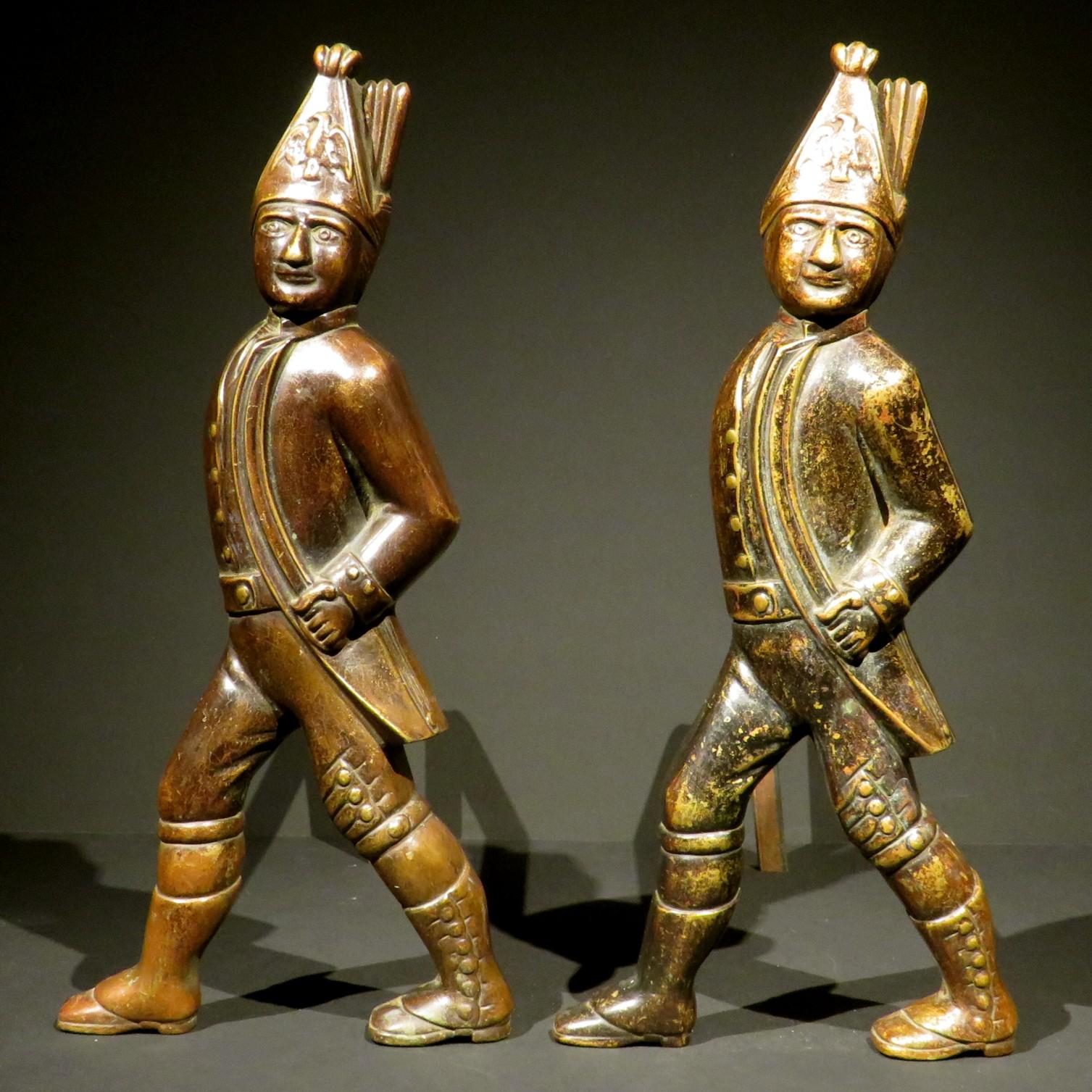 A rare pair of 19th century Hessian Soldier andirons richly cast in thick gauge bronze, finely modelled and weighing approximately 14 pounds each, (without their forged iron supports). 
Both exhibiting a patinated surface and a fine patina overall,