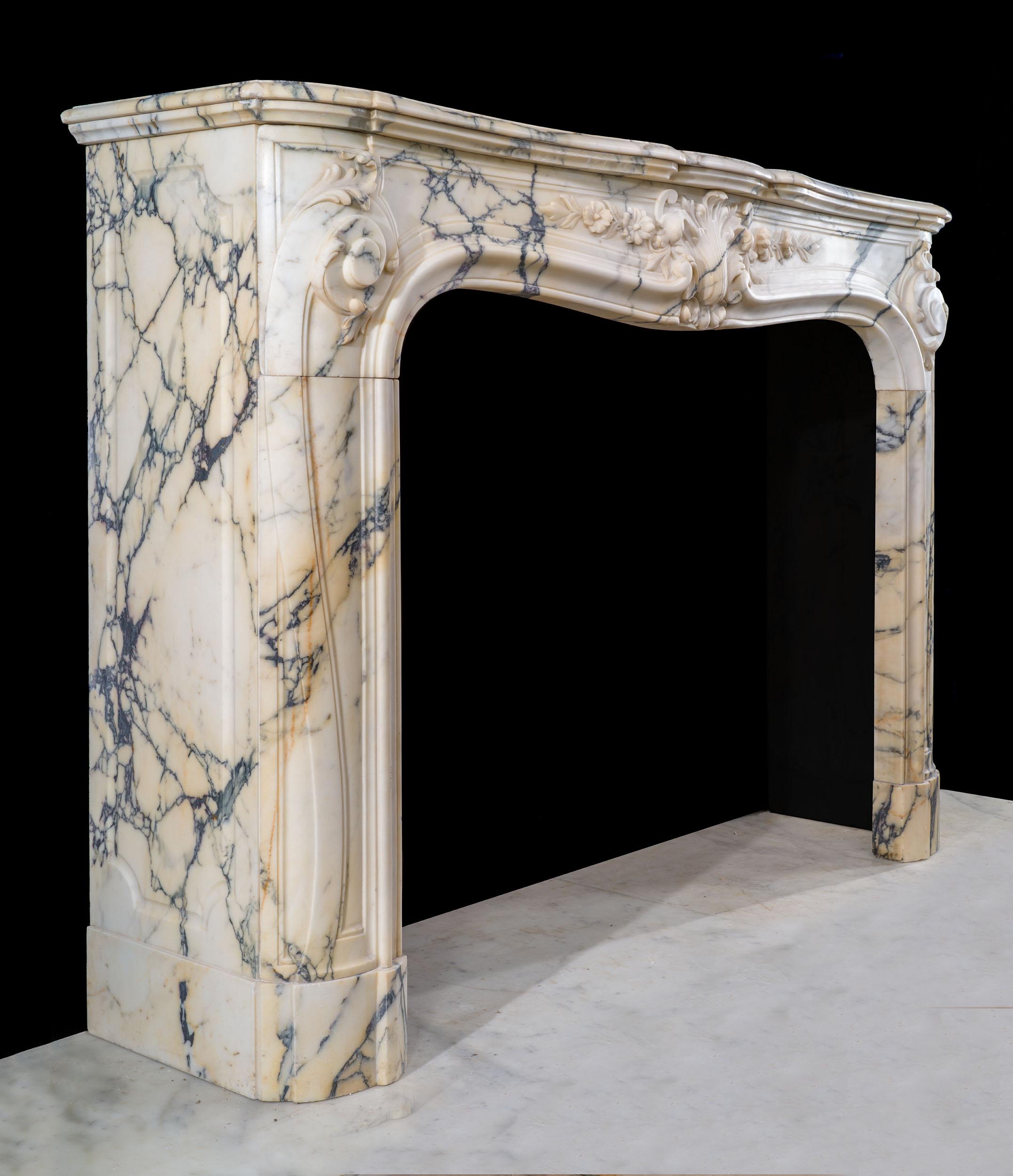 Une rare paire de très belles cheminées en marbre rococo Louis XV dans un marbre seravezza magnifiquement veiné. Sur chacune d'entre elles, la tablette serpentine est montée sur la frise serpentine, magnifiquement sculptée d'un cartouche central en