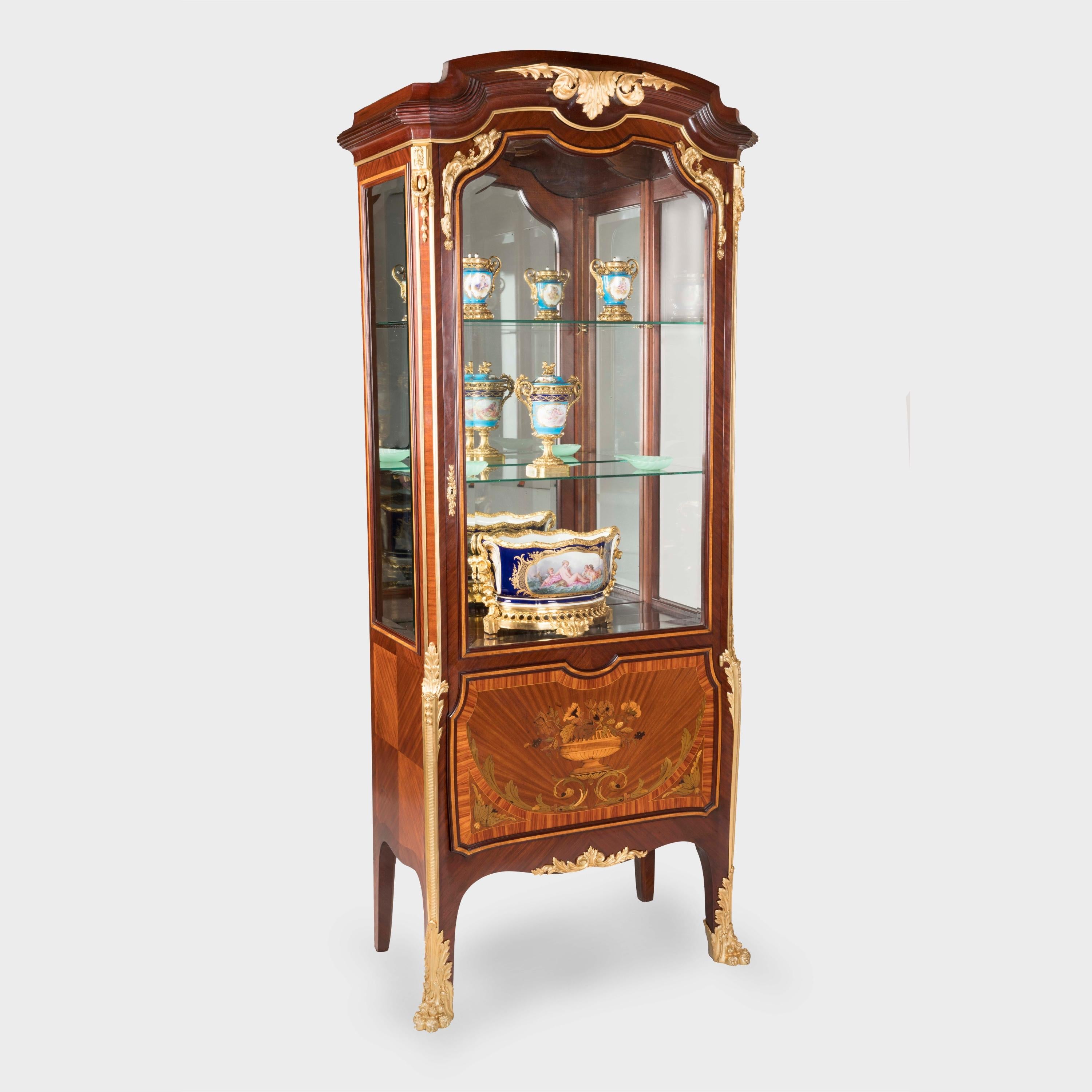 A pair of Marquetry display cabinets
in the transitional manner

By Edmund Kahn of London & Paris 

Constructed from kingwood, with tulipwood, bois satiné and harewood inlays; finished with extensive ormolu mounts; each cabinet supported on
