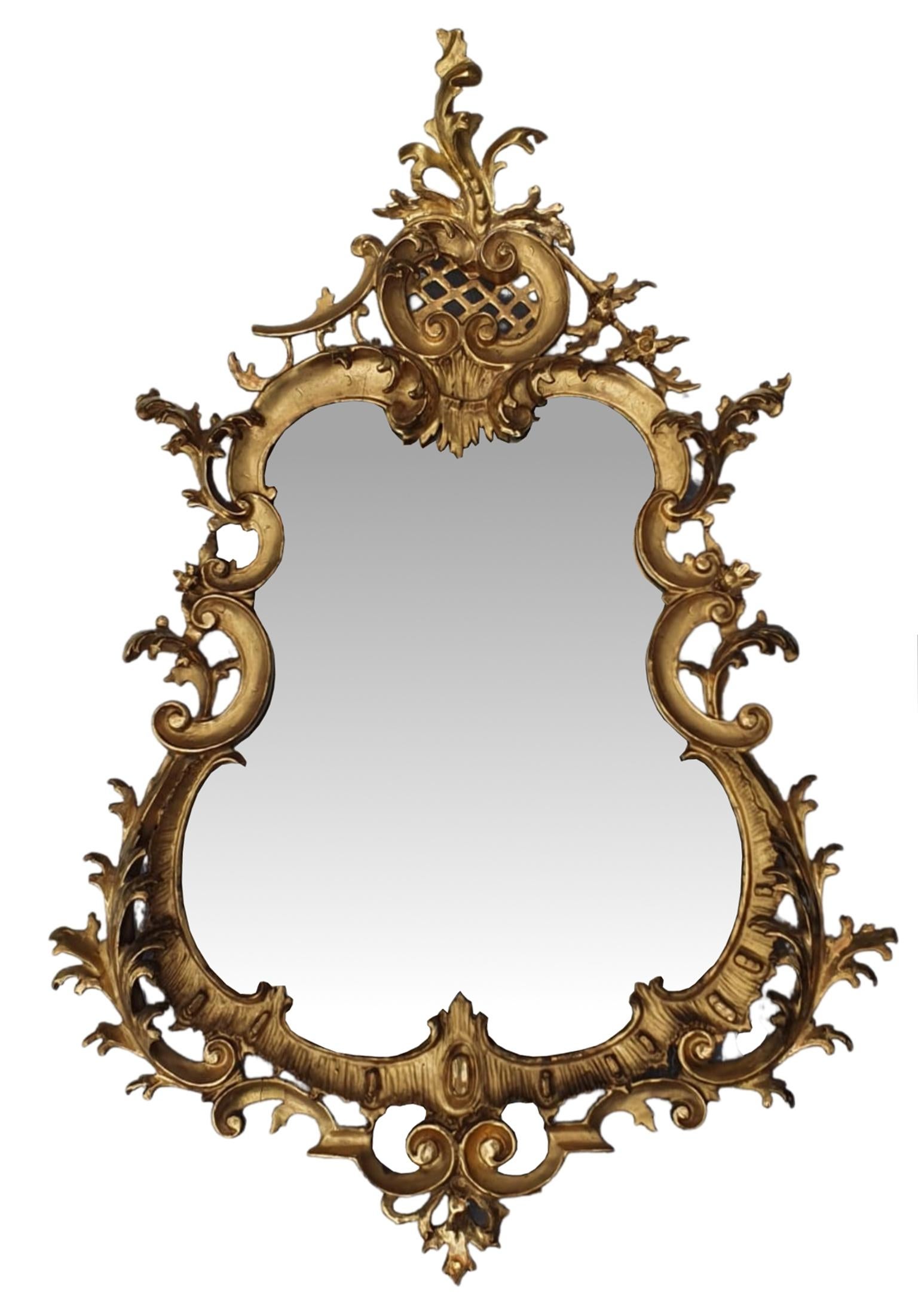 Rara coppia di specchi in legno dorato del XIX secolo in stile rococò. Un'eccezionale coppia di specchi da molo, la cui lastra sagomata è incastonata in una cornice traforata intricatamente intagliata a mano con volant, volute a C, motivi fogliacei