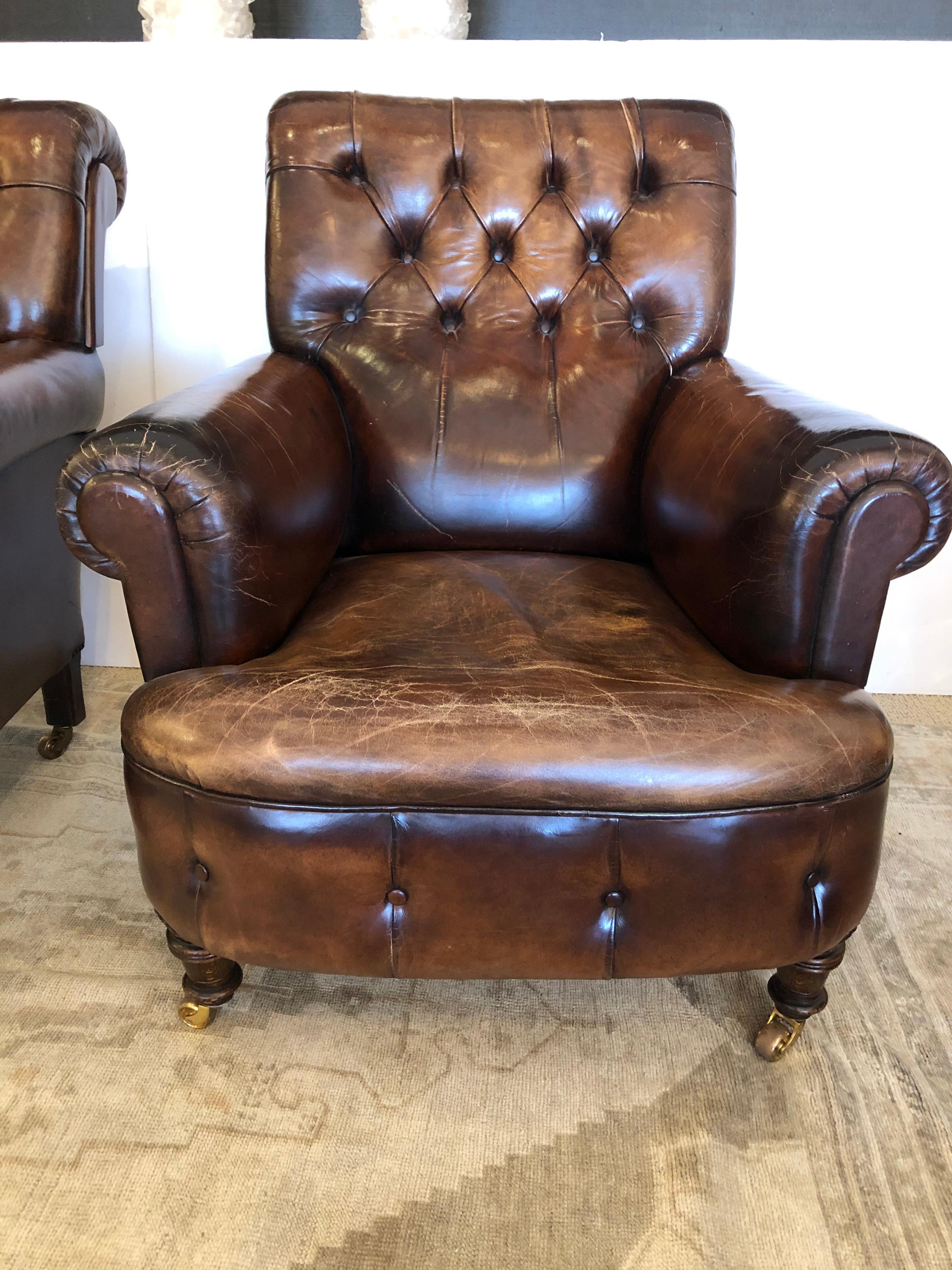 Luscious 19th century tobacco slightly distressed leather club chairs worn in all the right places, having tufted backs, rolled arms, buttons around the bases, and mahogany legs on brass casters. A rare find.
Measures: seat depth 22, arm height