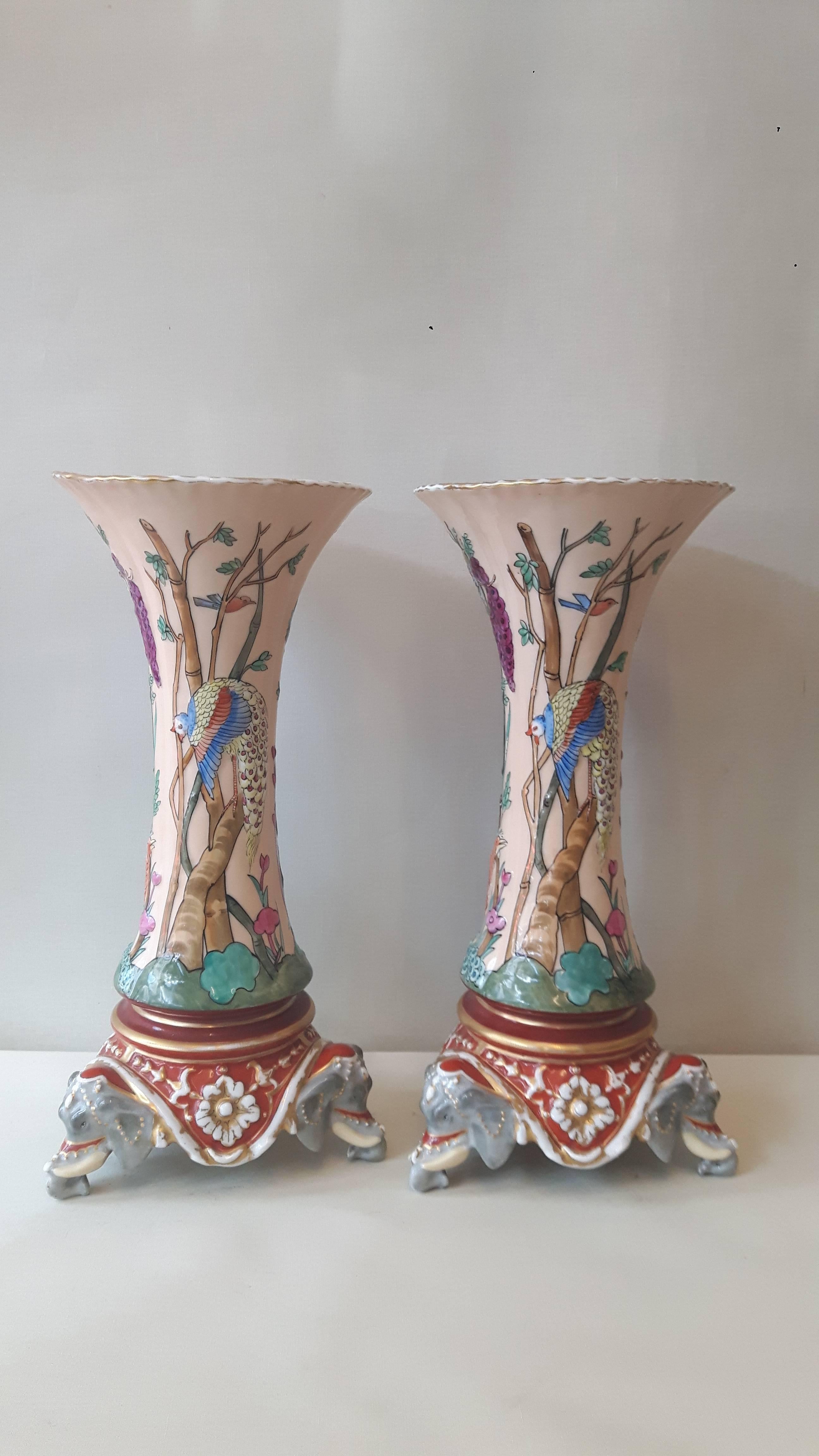 Une paire extrêmement inhabituelle de vases en forme de trompette en porcelaine de Paris dans le style indien Mogul du 18e siècle, décorés à la main d'oiseaux exotiques dans des arbres et du feuillage, le corps reposant sur des têtes d'éléphants en
