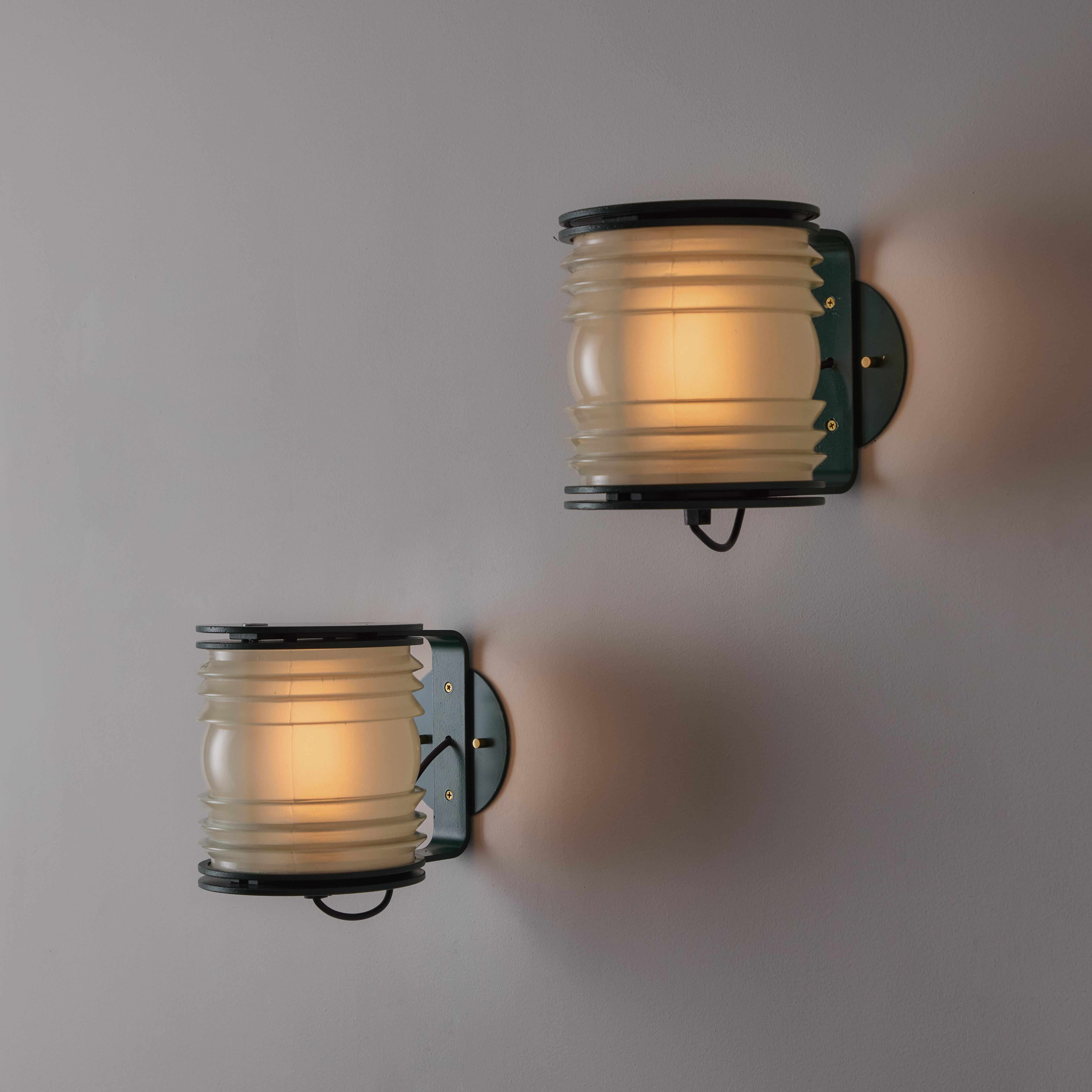 Pair of Rare 1st Edition Model 1139 Fresnel sconces by Joe Colombo for Oluce. Designed and manufactured in Italy, circa 1960's. Molded glass with rippled compression forms and a beautiful green finish. The light receives a single E27 socket-type,