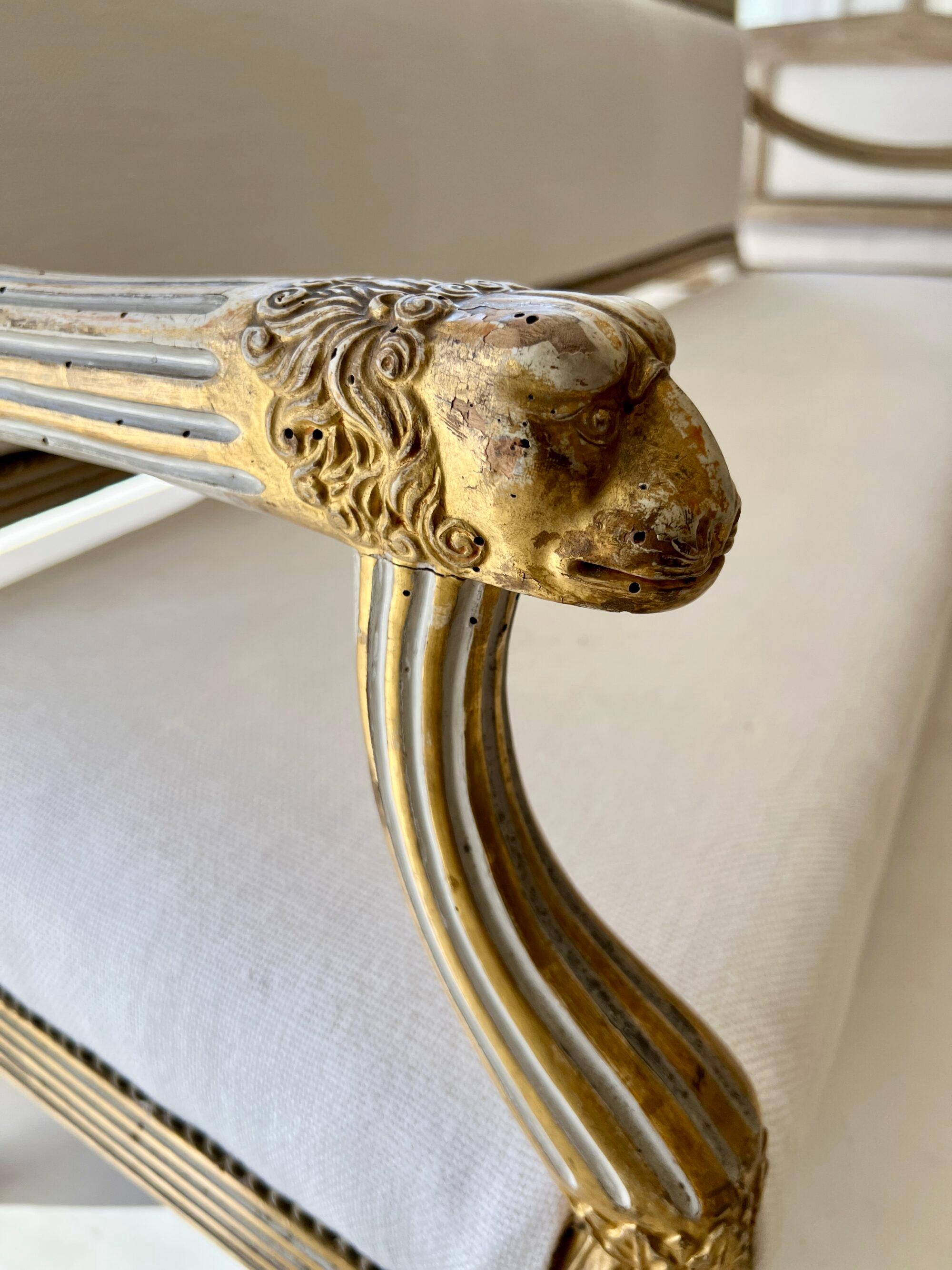 Raro e importante par de bancos neoclásicos del siglo XVIII -1er Imperio- procedentes de Parma, que conservan su acabado dorado y policromado original. Cada uno con terminales de brazo de cabeza de león finamente tallados, símbolo de fuerza y