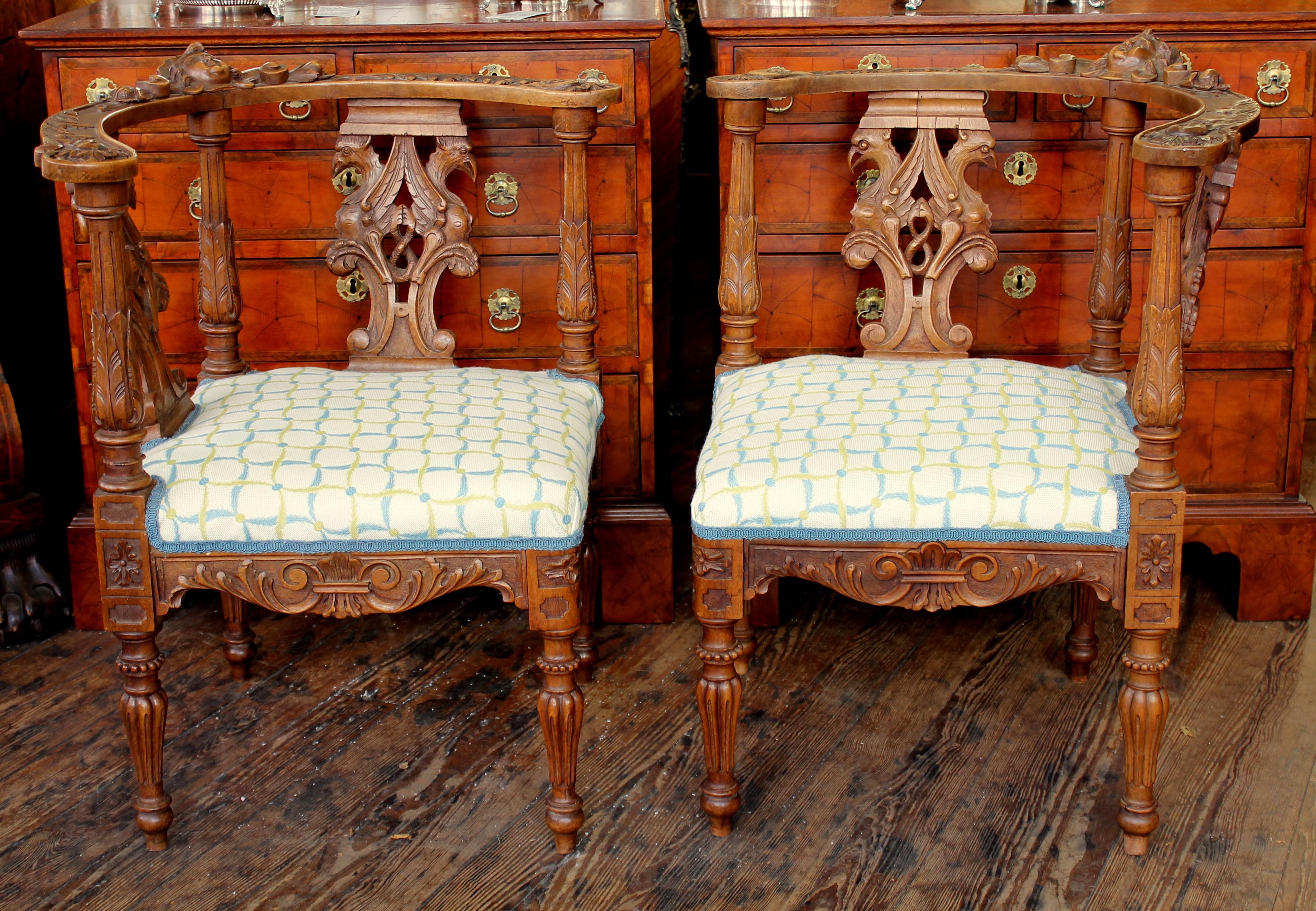 Rare and fine pair of antique Scottish hand-carved walnut Renaissance style corner chairs.
Please note exceptional bas relief hand-carved motifs, in particular the cherub or putti mask heads. The double headed eagle carved back splats are also