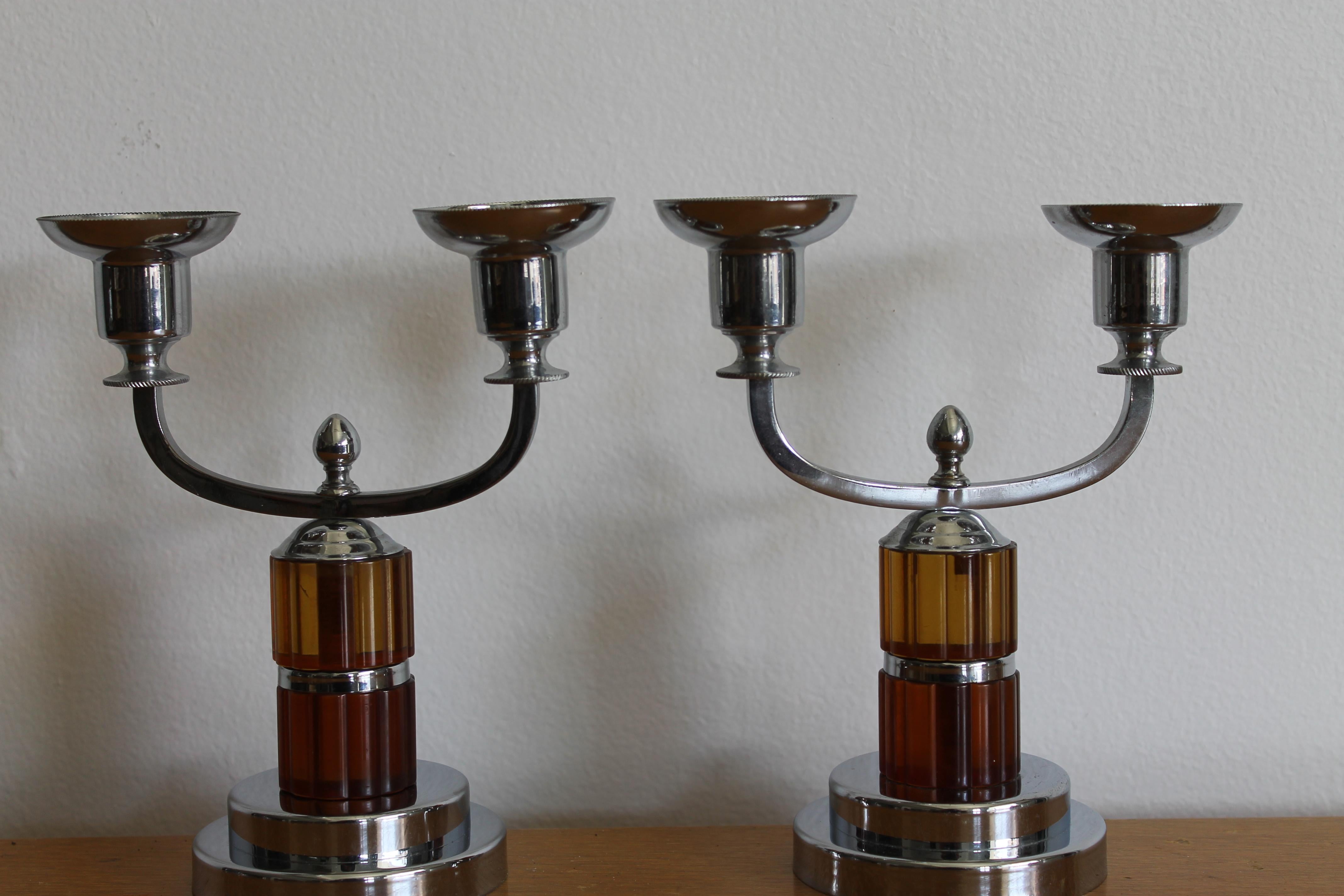 Chrome double armed candlesticks with clear Bakelite elements, one amber and one pale amber. These are marked FARBERWARE BROOKLYN NY and appear to be unused. Immaculate condition. Each candlestick measures: 6