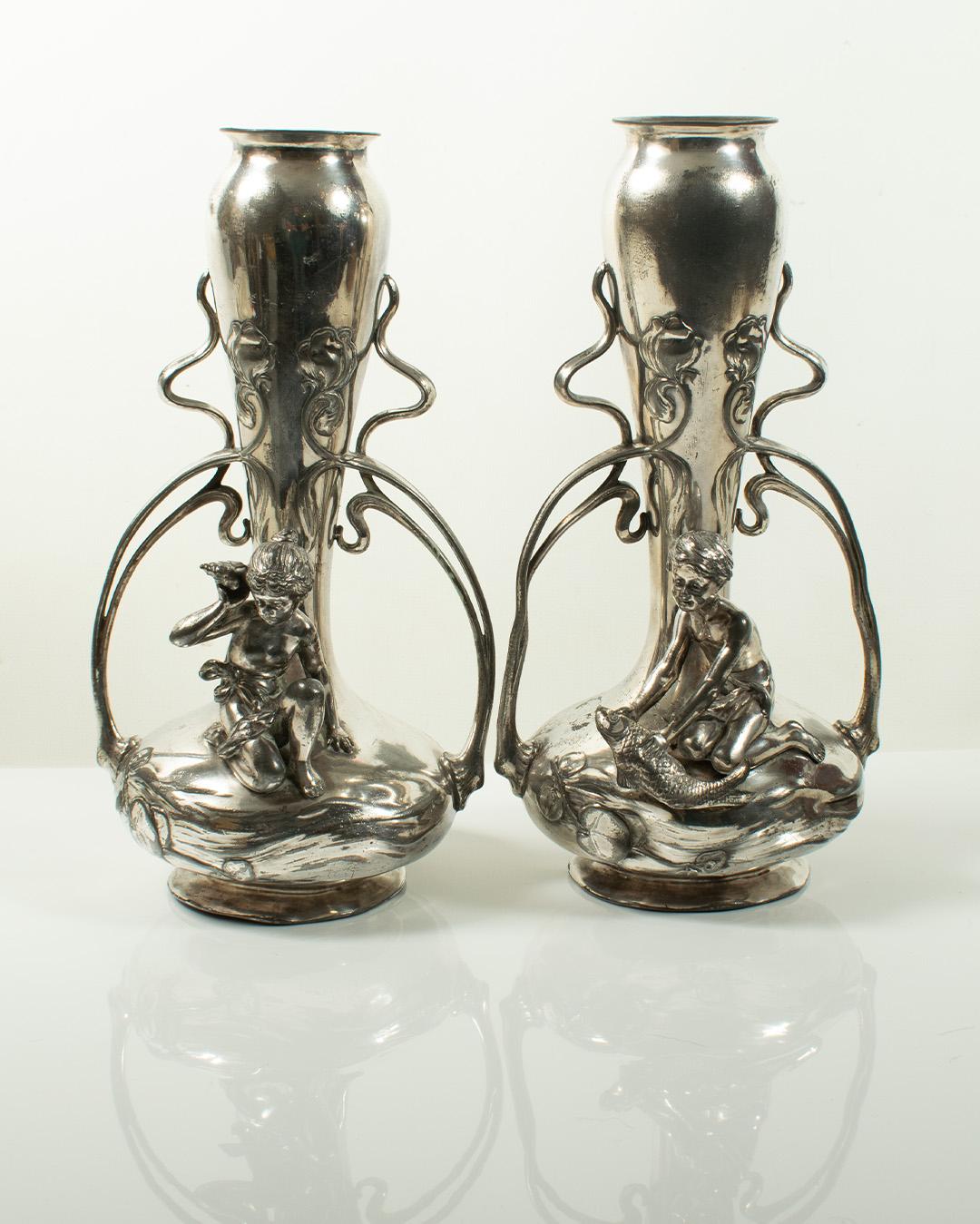 Rare Pair of Art Nouveau Silver-Plated Vases by WMF (c.1900)

A striking and rare pair of silver-plated Art Nouveau vases by WMF (Württembergische Metallwarenfabrik), circa 1900. Each vase features classic Jugendstil design elements: embossed