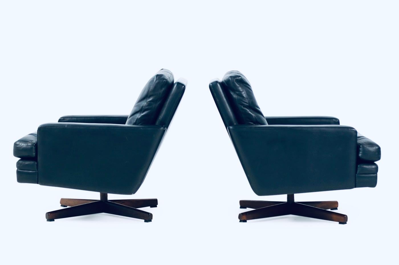Introducing an exquisite pair of leather lounge chairs that are sure to steal the show in any room. Don't let this rare find pass you by! The Fredrik A. Kayser for Vatne Mod. 807 leather and rosewood swivel lounge chairs are a masterpiece of