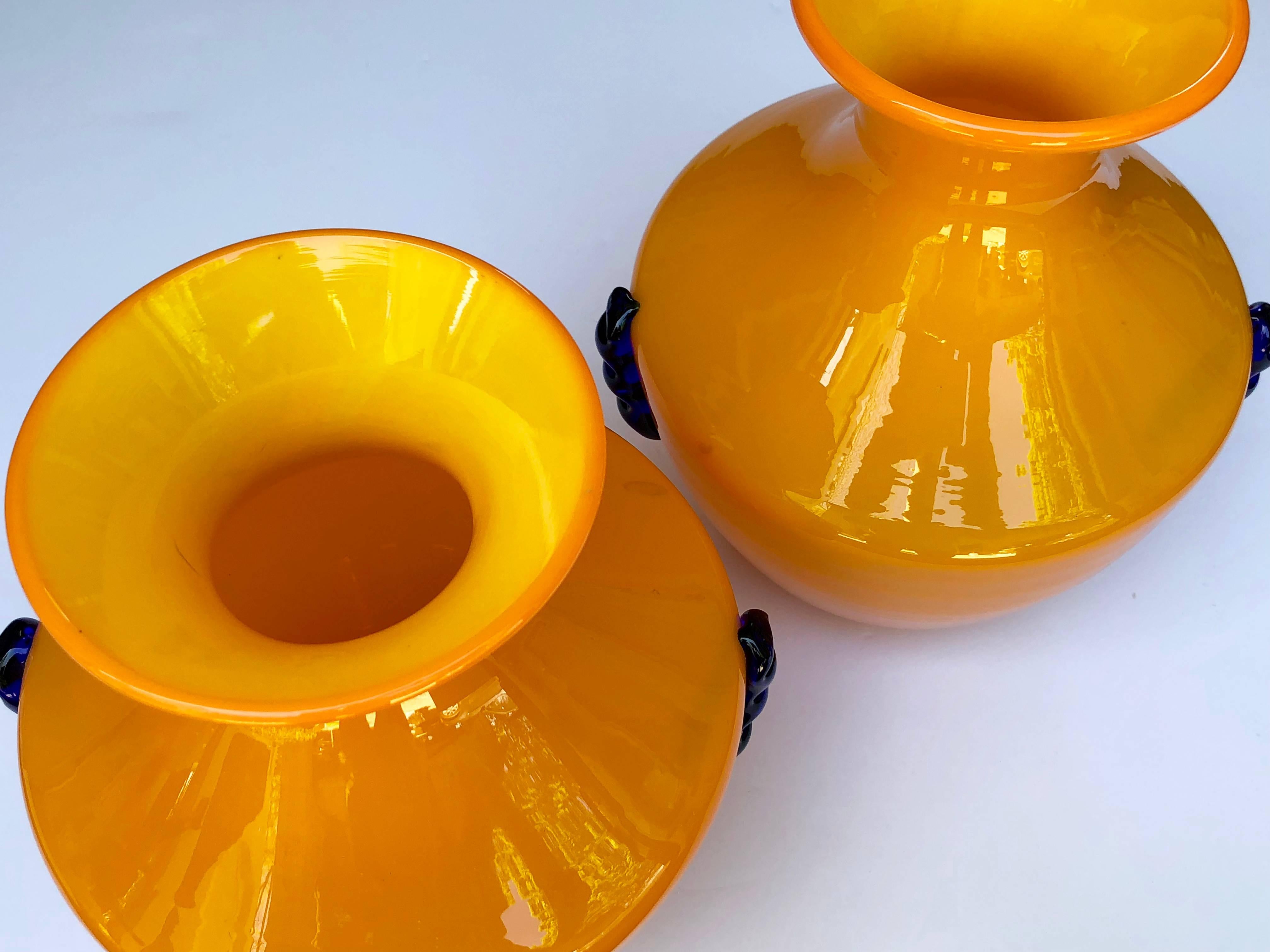 Manufactured by Blenko glassworks as part of their experimental line, these vases were never placed into production; with flared neck and ovoid body in a vibrant orange glass adorned with cobalt decoration.