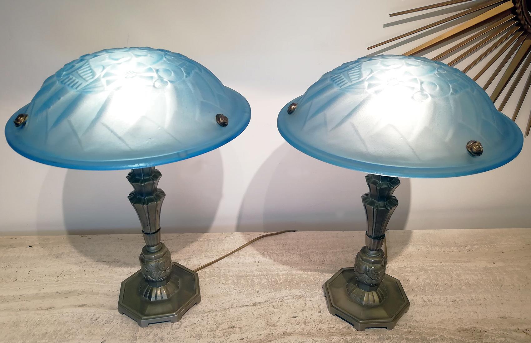 Beautiful pair of Art Deco table lamp, high quality molded glass panel (diameter: 35 cm) in blue color with floral motif design designed by Degue, supported by bronze metal column with beautiful geometric and floral motif design. Charming when