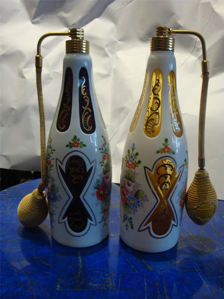 The Following Item we are offering is this Rare Set of TWO Large Estate Bohemian Amethyst and White, Yellow and White Handpainted Moser Perfume Bottles. Handpainted with Floral Detail. Circa 1900's.They were purchased from Bergdorff Goodman's