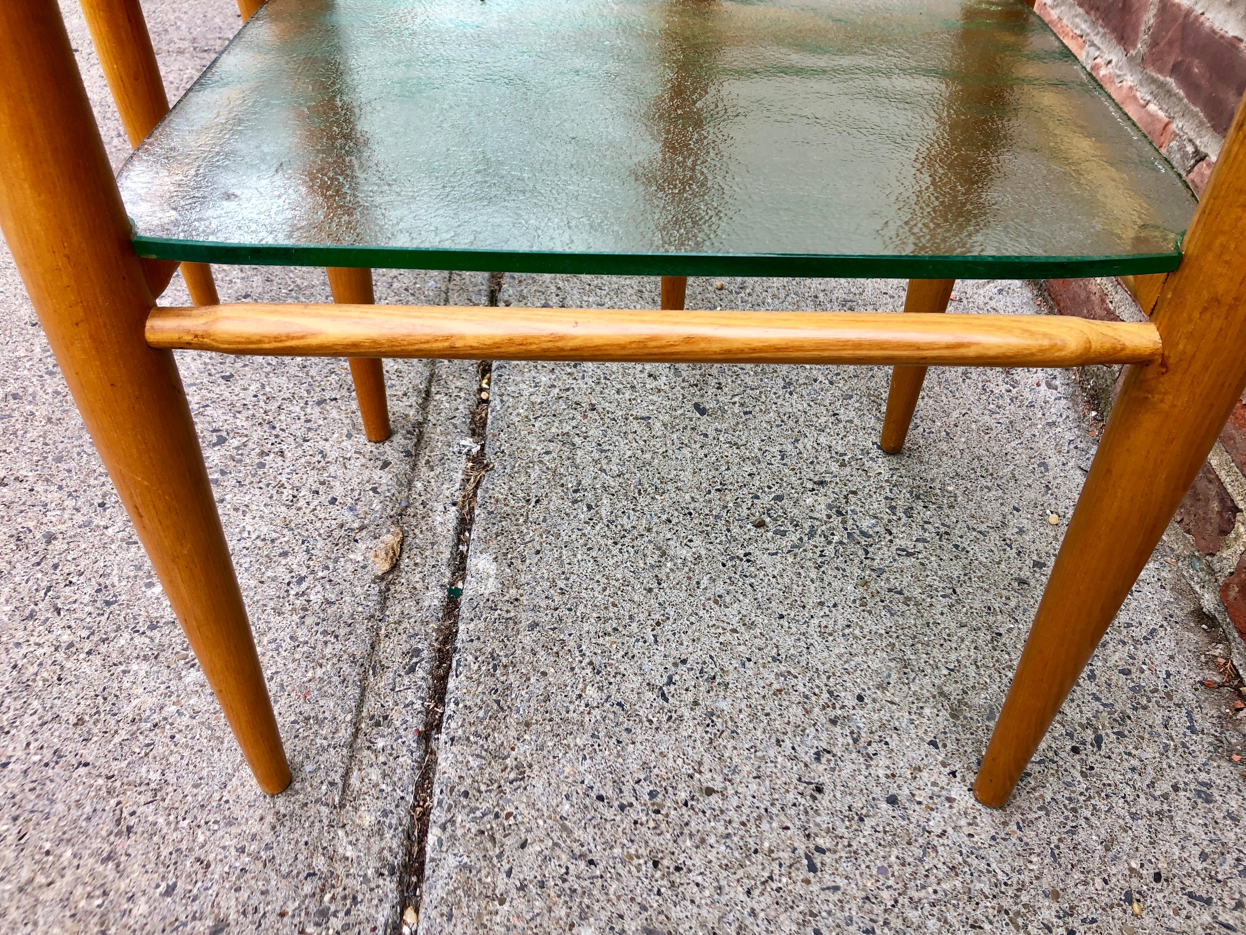 Custom two-tier oak dowel tables with 1/2 inch textured glass shelves. The simple designs belies marvelous construction technique such as invisible inset shelf supports, and each glass pane custom cut to fit its shelf.