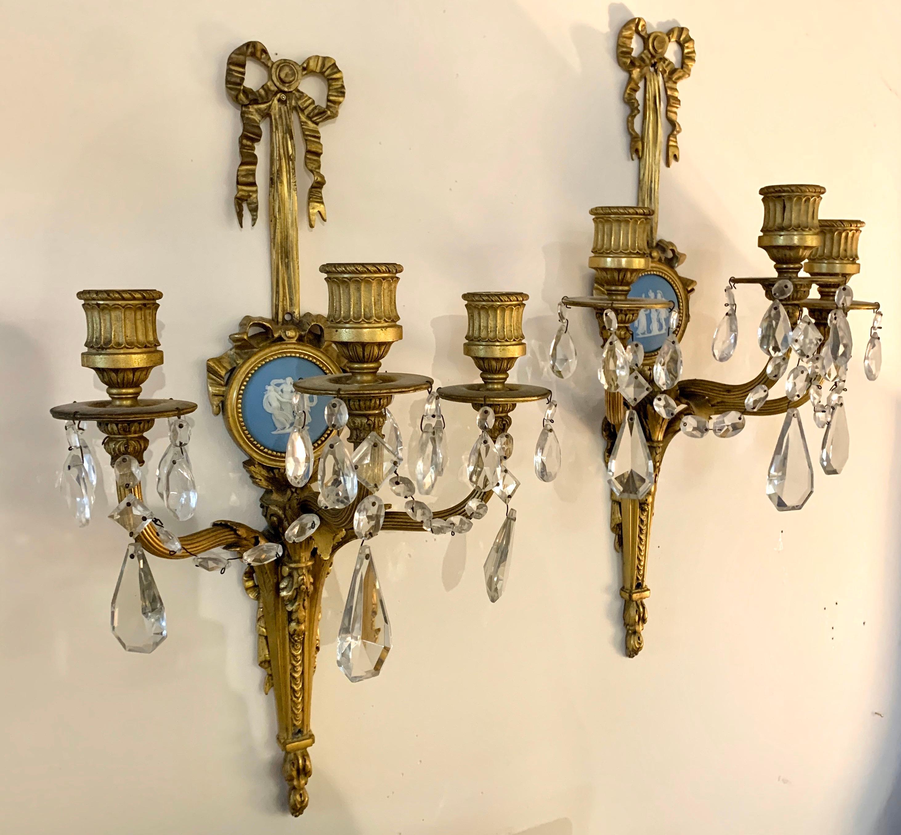 A magnificent pair of antique Louis XVI style doré bronze and Wedgwood mounted three arm candle sconces/wall appliques signed by E. F. Caldwell & Co New York. The Caldwell monogram is prominent on the back. Each sconce has been hand chiseled and