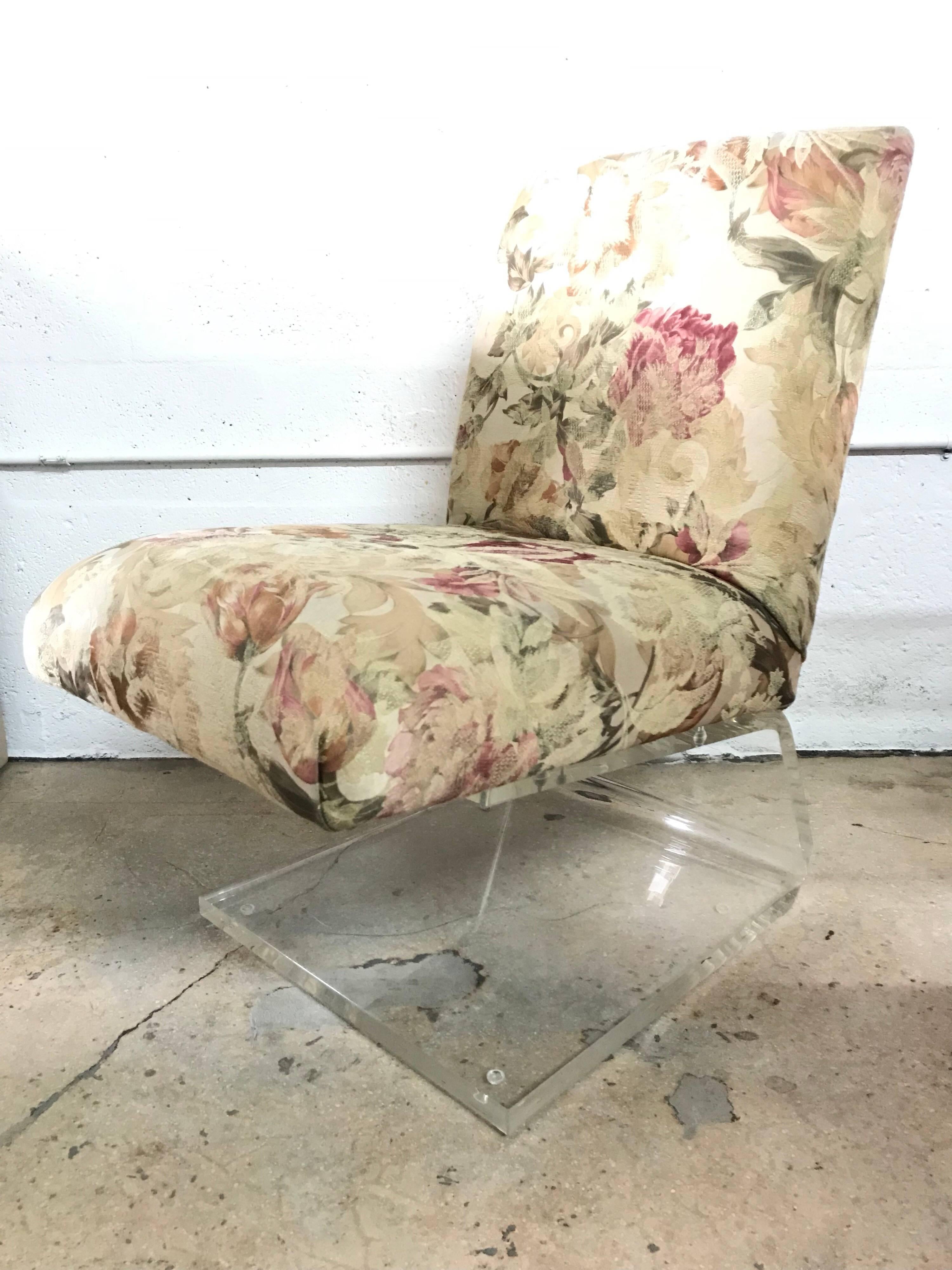 Rare slipper chairs rendered in thick Lucite with floral upholstery.