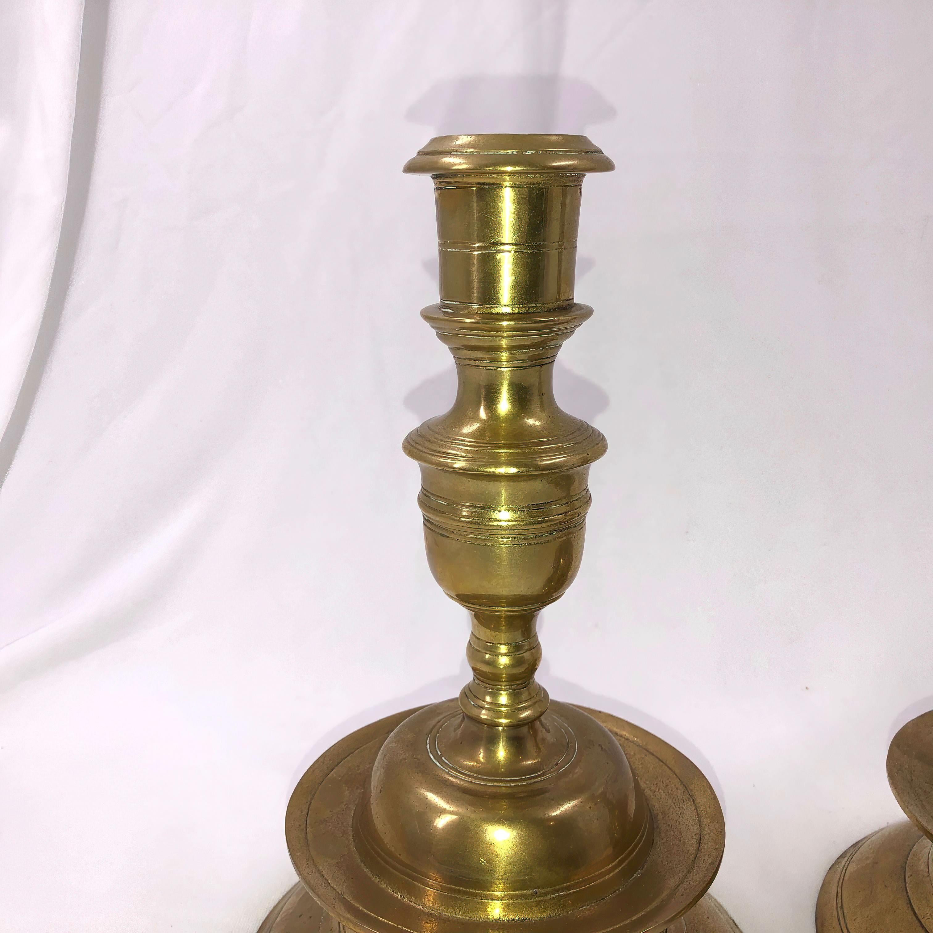 A rare and large pair of brass capstan candlesticks with mid drips.