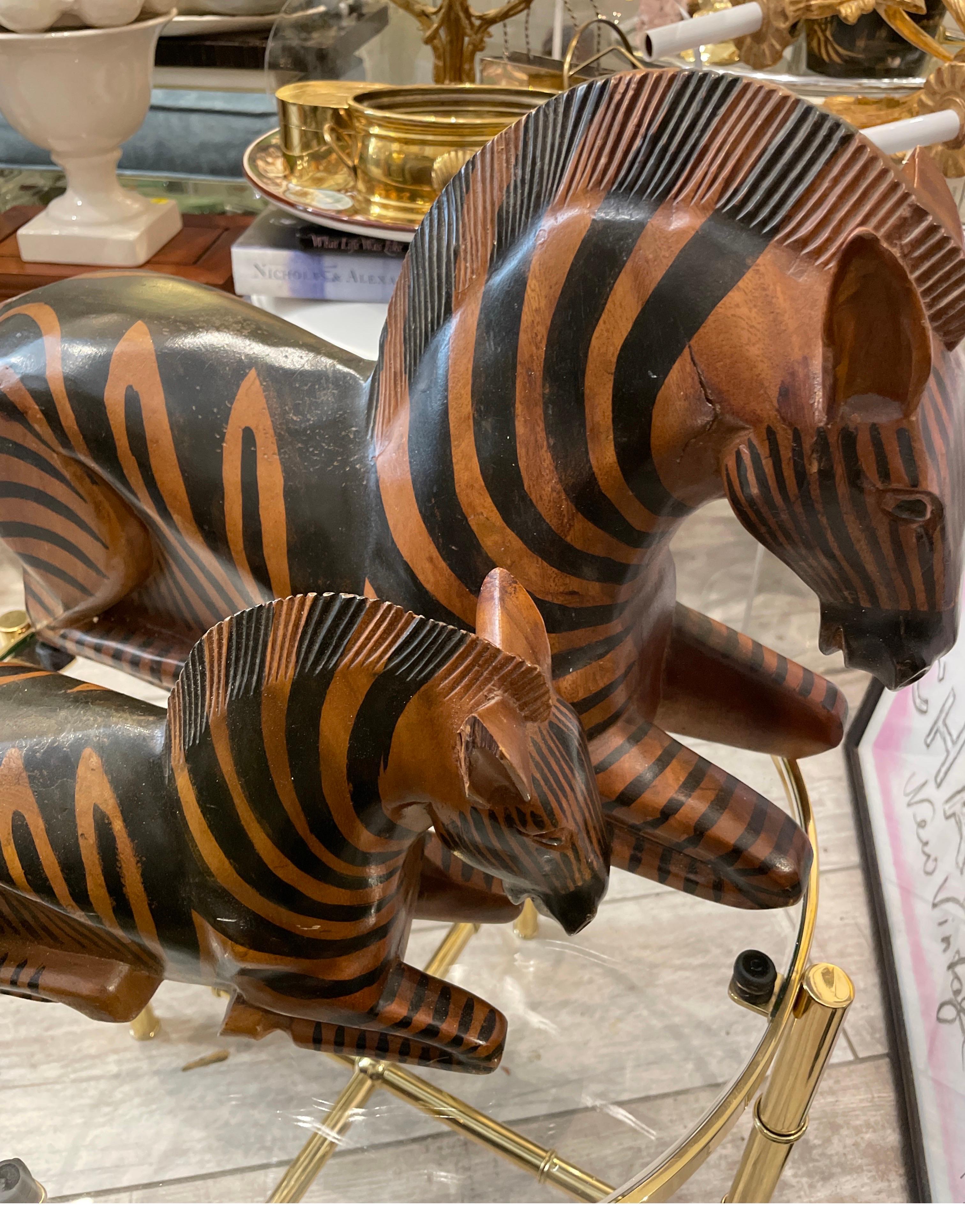 Una rara coppia di zebre in legno intagliato di Arthur Court per Bloomingdale's. La coppia presenta una madre e un bambino. Il bambino misura 12