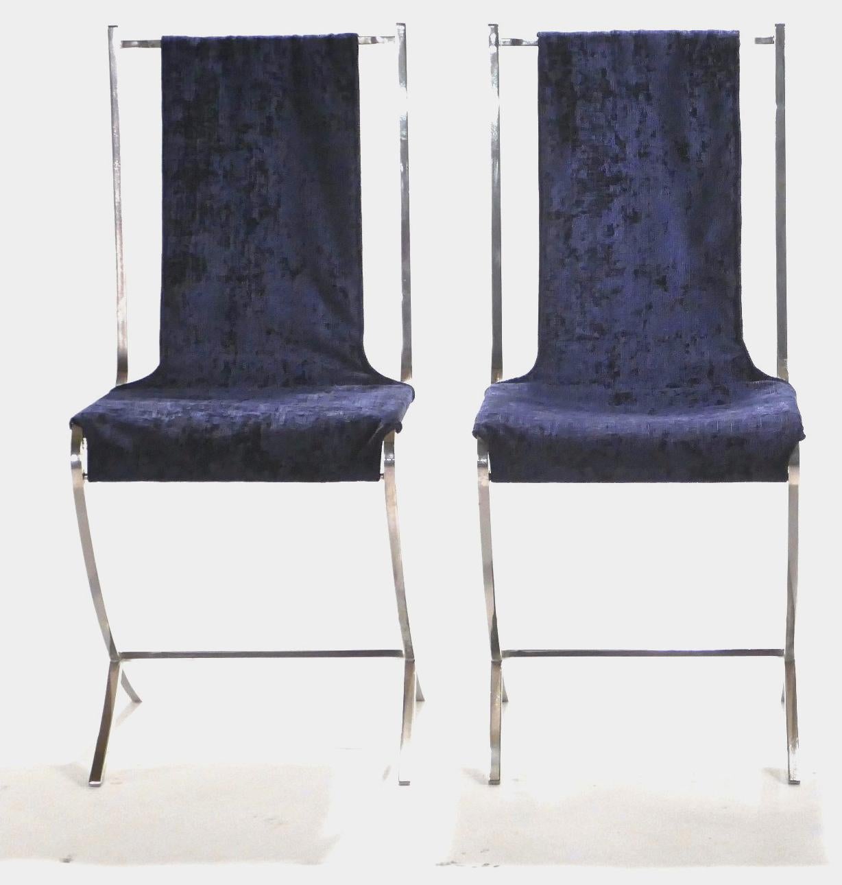 Lounge on extravagant deep blue velvet, suspended across a sturdy, but artfully imagined structure made of heavy nickeled metal. This pair of chairs was created by French avant-garde designer Pierre Cardin for well-known interior design firm Maison
