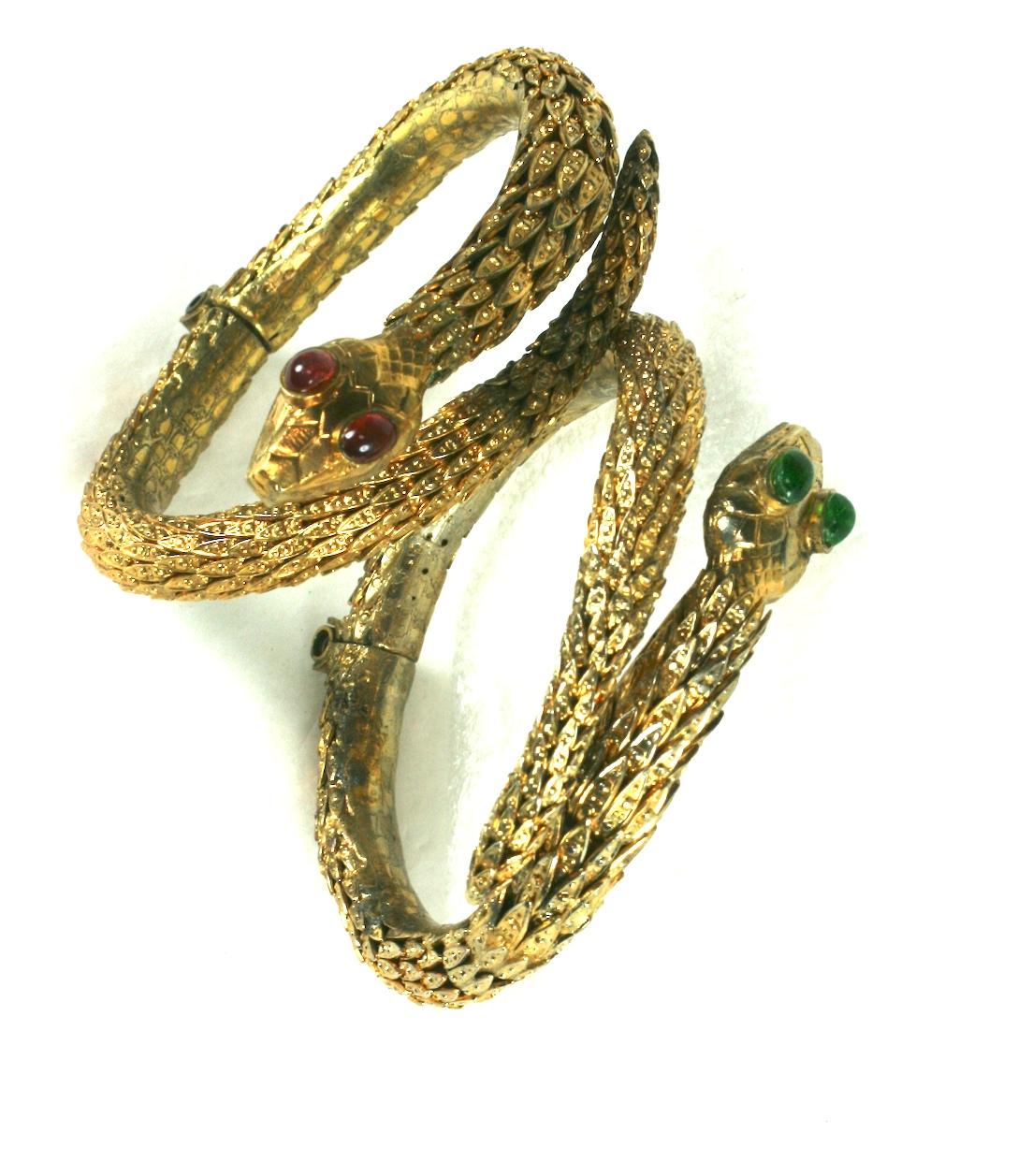 Rare Pair of Period Haute Couture Chanel Snake Bangles by Maison Goossens. These hand made hinged bracelets are composed of dozens of graduated gilt filigree caps soldered together to form the body of each bracelet. Each snake head is hand made with