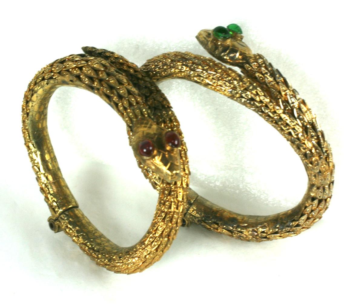 Rare Pair of Period Haute Couture Chanel Snake Bangles by Maison Goossens. These hand made hinged bracelets are composed of dozens of graduated gilt filigree caps soldered together to form the body of each bracelet. Each snake head is hand made with