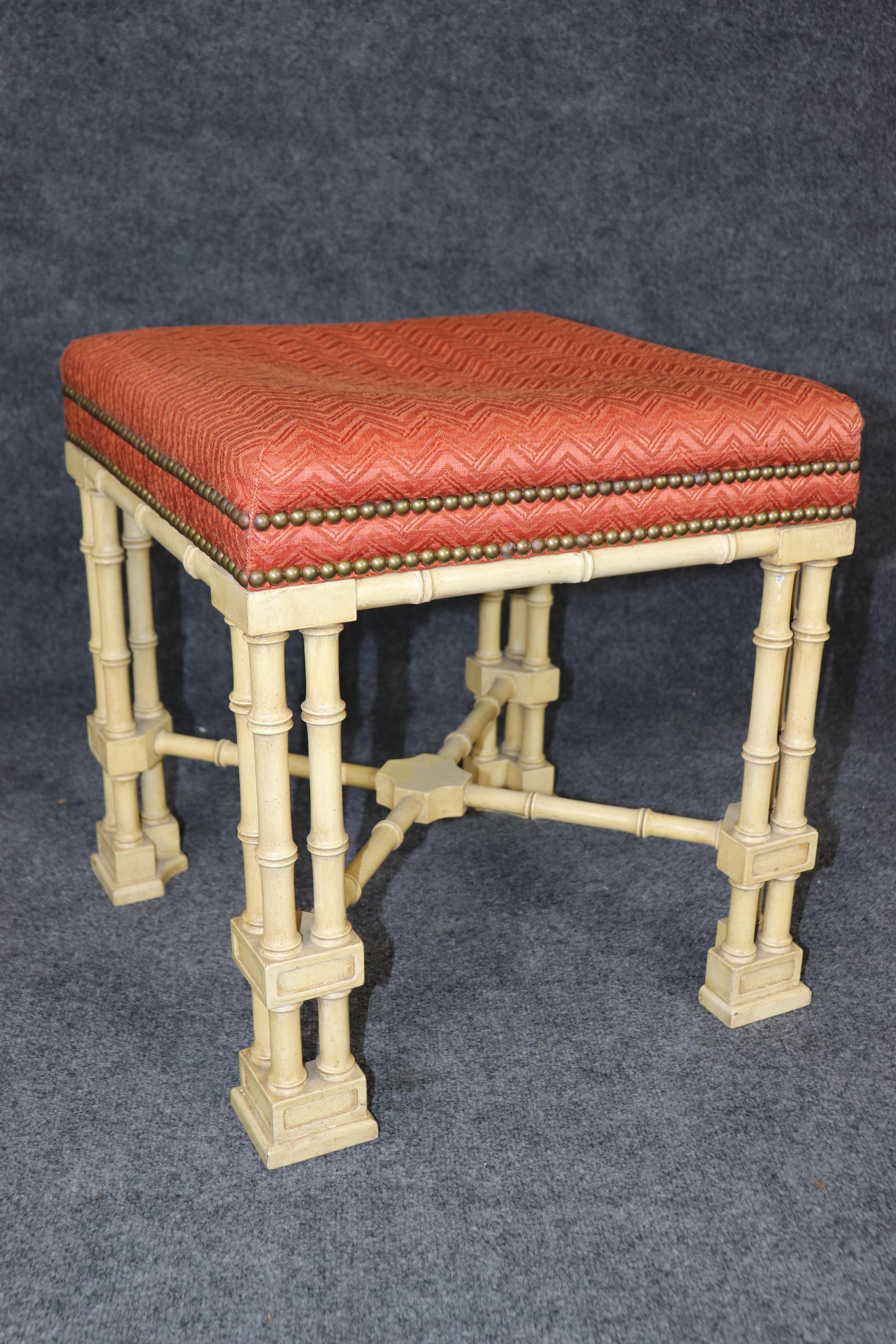 This is a gorgeous pair of English-made Chinese Chippendale stools with beautiful ivory painted frames and faux bamboo carved legs. The upholstery is in usable condition, but one seat does show a worn through area that may not bother you. The stools