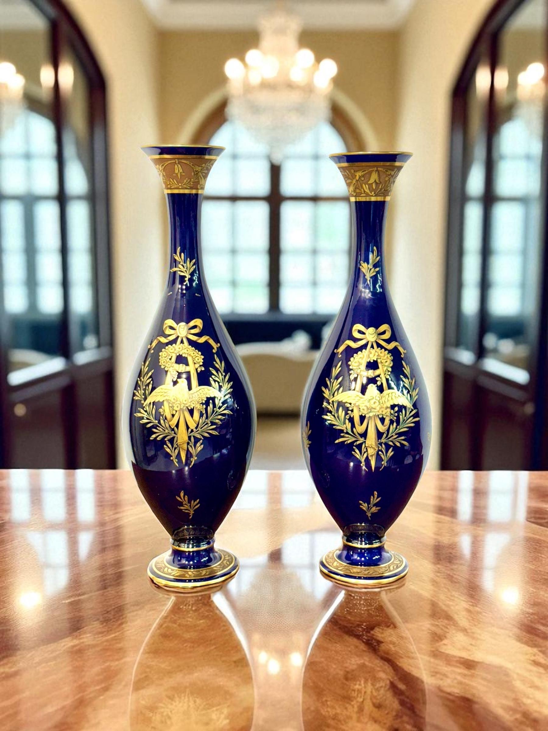 Este elegante par de jarrones en forma de ánfora de color azul cobalto fue producido por la distinguida manufactura Jaget & Pinon de Tours, Francia, y data del periodo Art Déco, hacia 1920-1930. Con sus alargadas formas de balaustre, cuellos