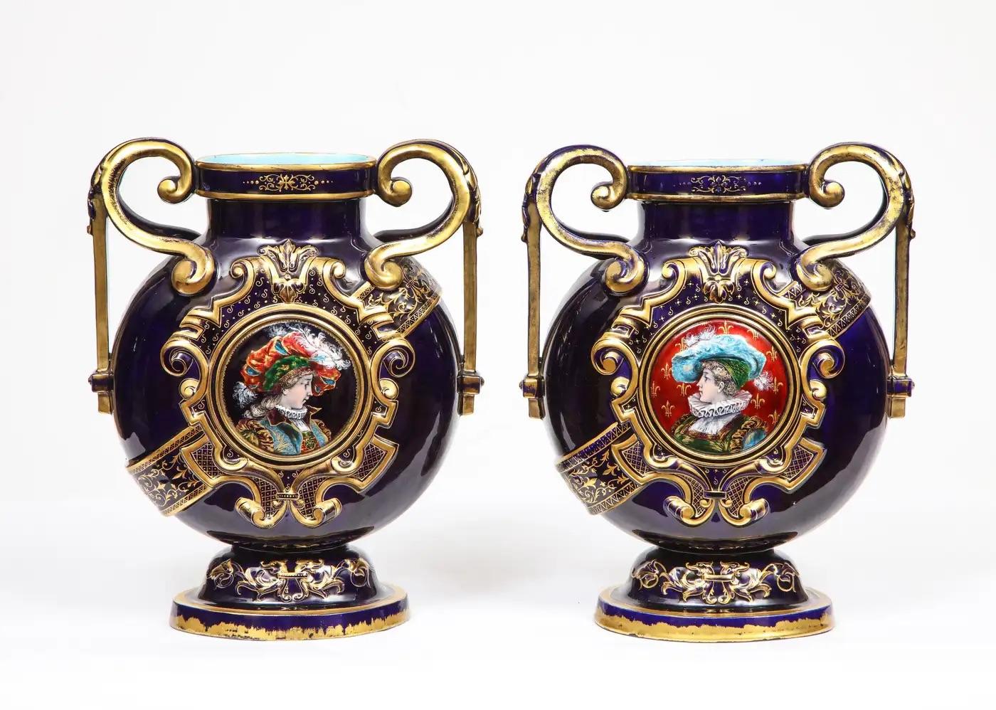 A rare pair of Emile Galle cobalt blue porcelain and Limoges enamel portrait vases. France, late 19th century.  

Elaborately gilded to a deep cobalt ground with gilt highlights throughout, with central Limoges enamel roundel medallions to each 