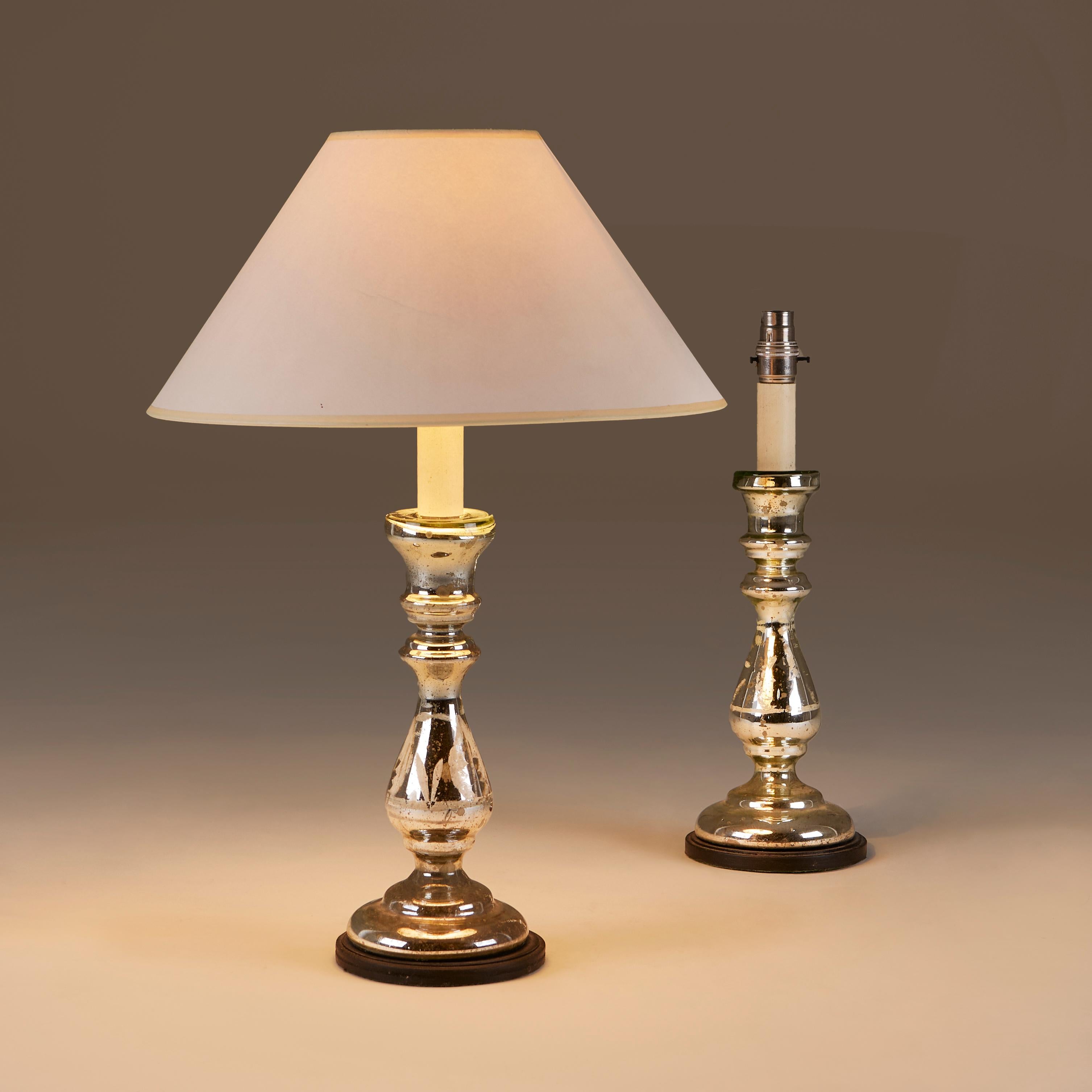 Well proportioned elegant and practical pair of English mercury glass column table lamps with ebonised wood bases. Lovely vintage patina.
