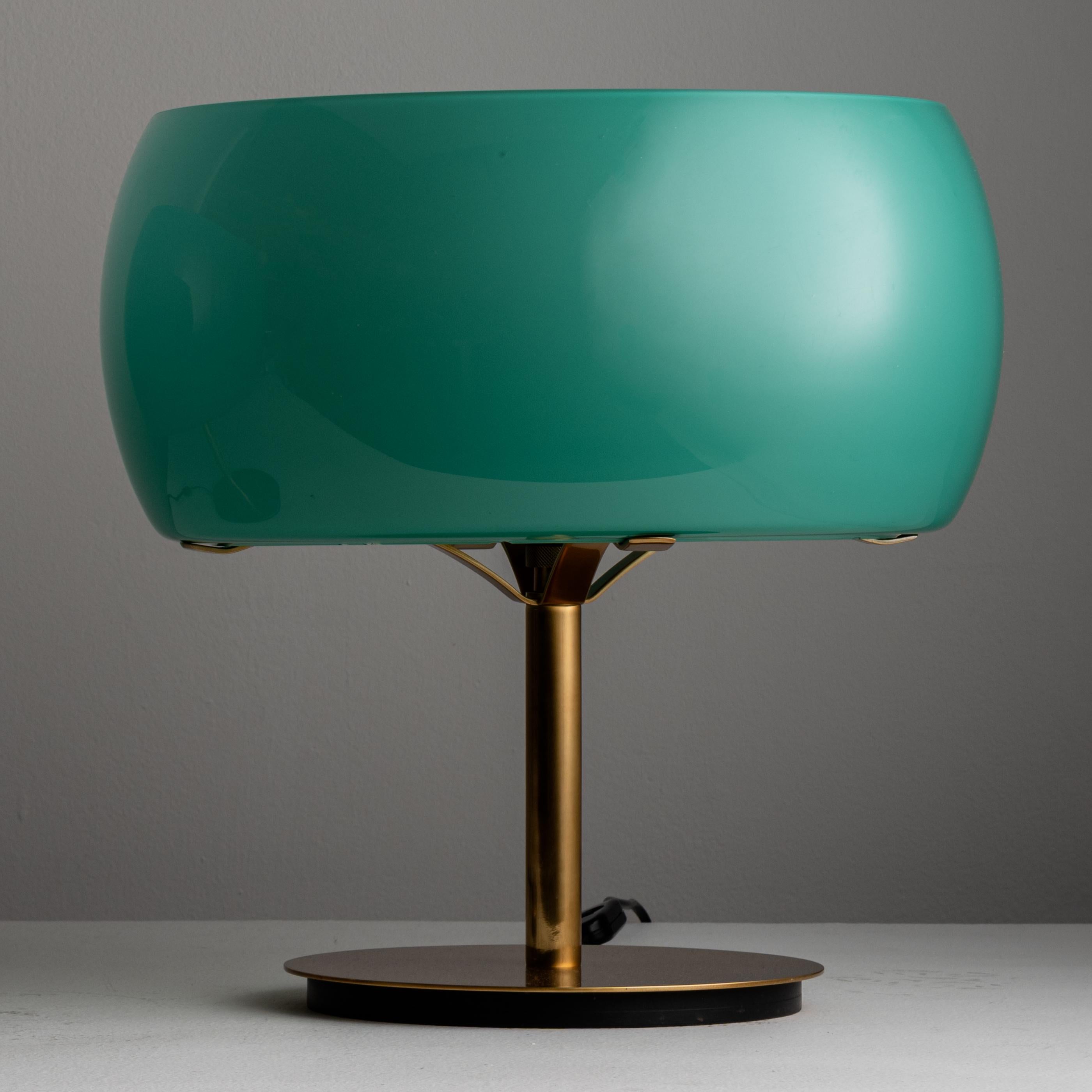 Rare pair of 'Erse' Table Lamps by Vico Magistretti for Artemide. Designed and manufactured in Italy, 1964. The base and stem of the lamp is constructed of polished brass. External orbital shade is made of teal colored glass which wraps around a