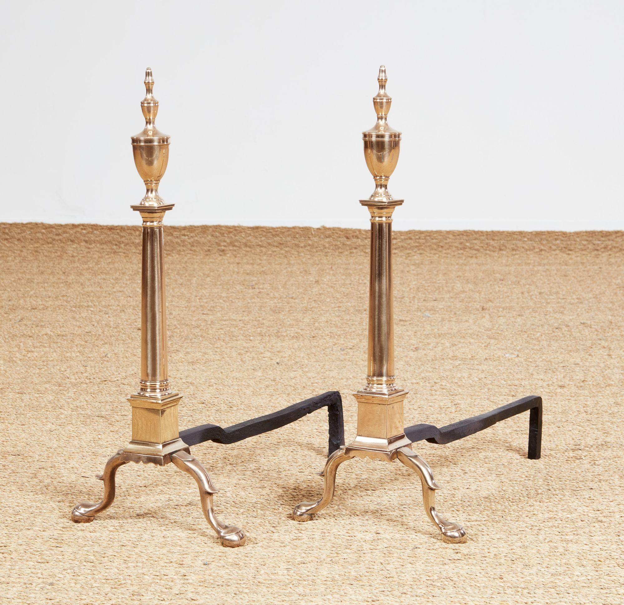 Fino y raro par de morillos clásicos de metal acampanado de Filadelfia, con remates en forma de urna sobre fustes de columnas dóricas que descansan sobre zócalos con bases festoneadas y se apoyan en patas cabriolé con rodillas de espolón y pies de