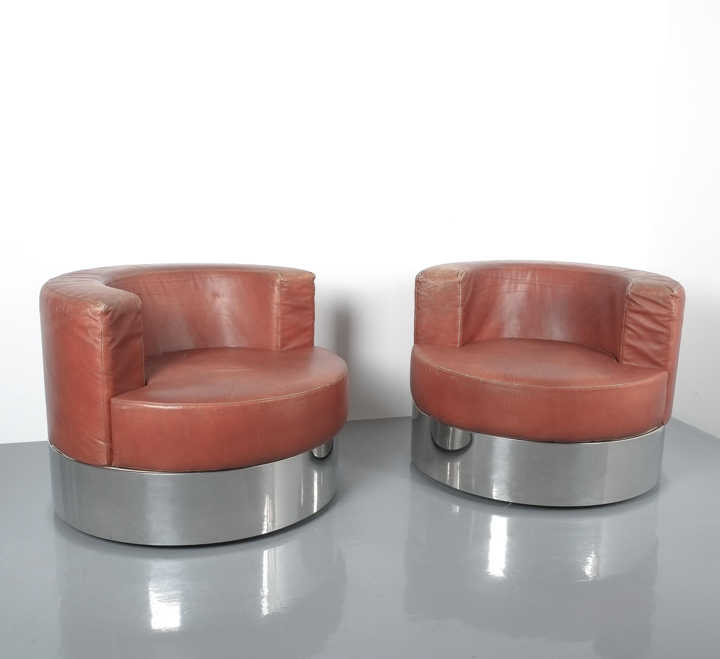 Rare pair of Franco Fraschini brown leather chairs for Driade, Italy, 1965. Stylish geometrical pair of leather chairs on a chrome base or socket with casters to move the chairs around. The condition is good with some wear and patina to the leather.