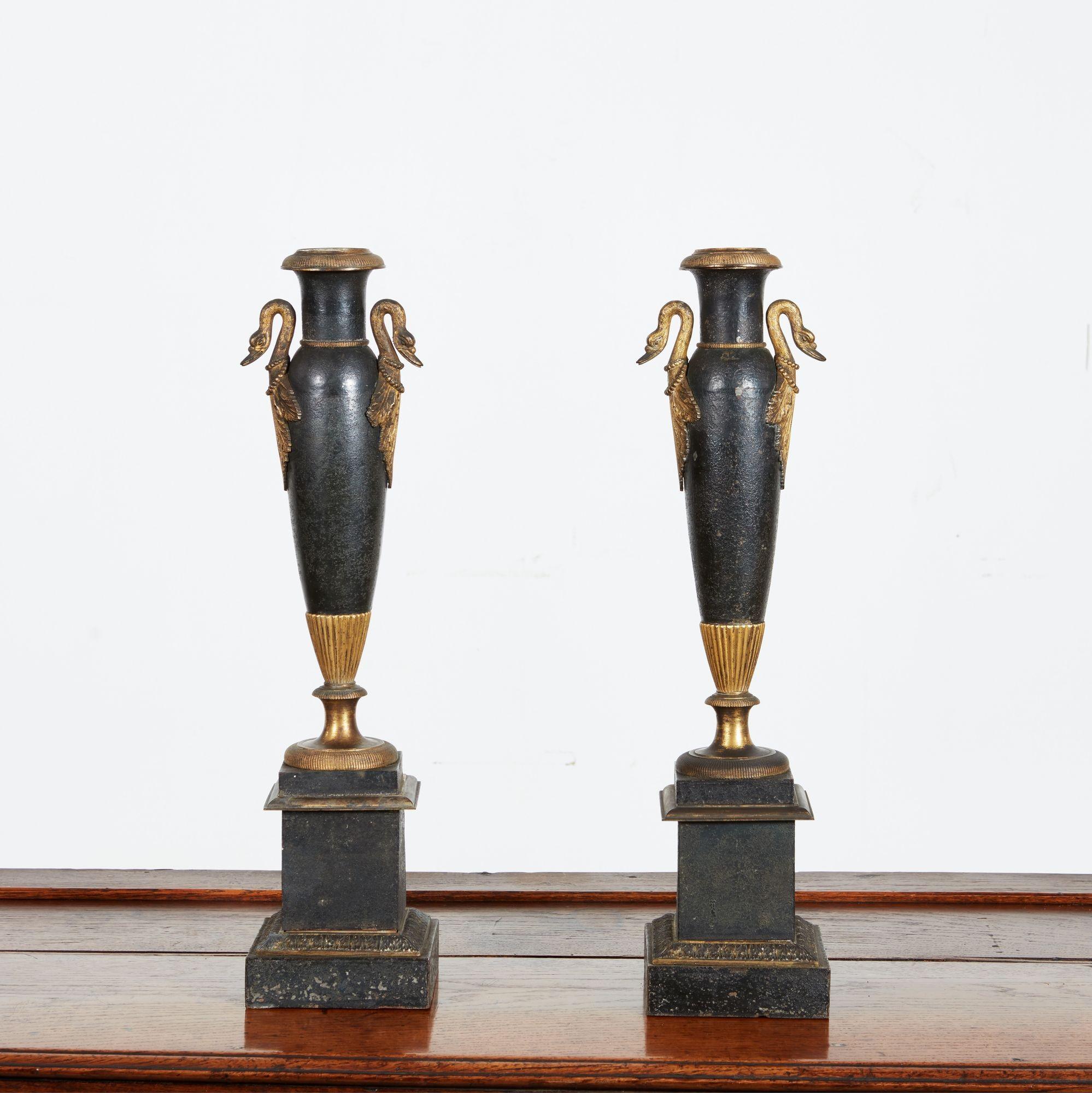 Rare paire de lampes Bouillotte d'époque Directoire en laque noire et dorée d'origine, avec des poignées en forme de cygne, des corps vasiformes et un socle, maintenant électrifiées (installées à l'intérieur de l'abat-jour, de sorte que le bougeoir