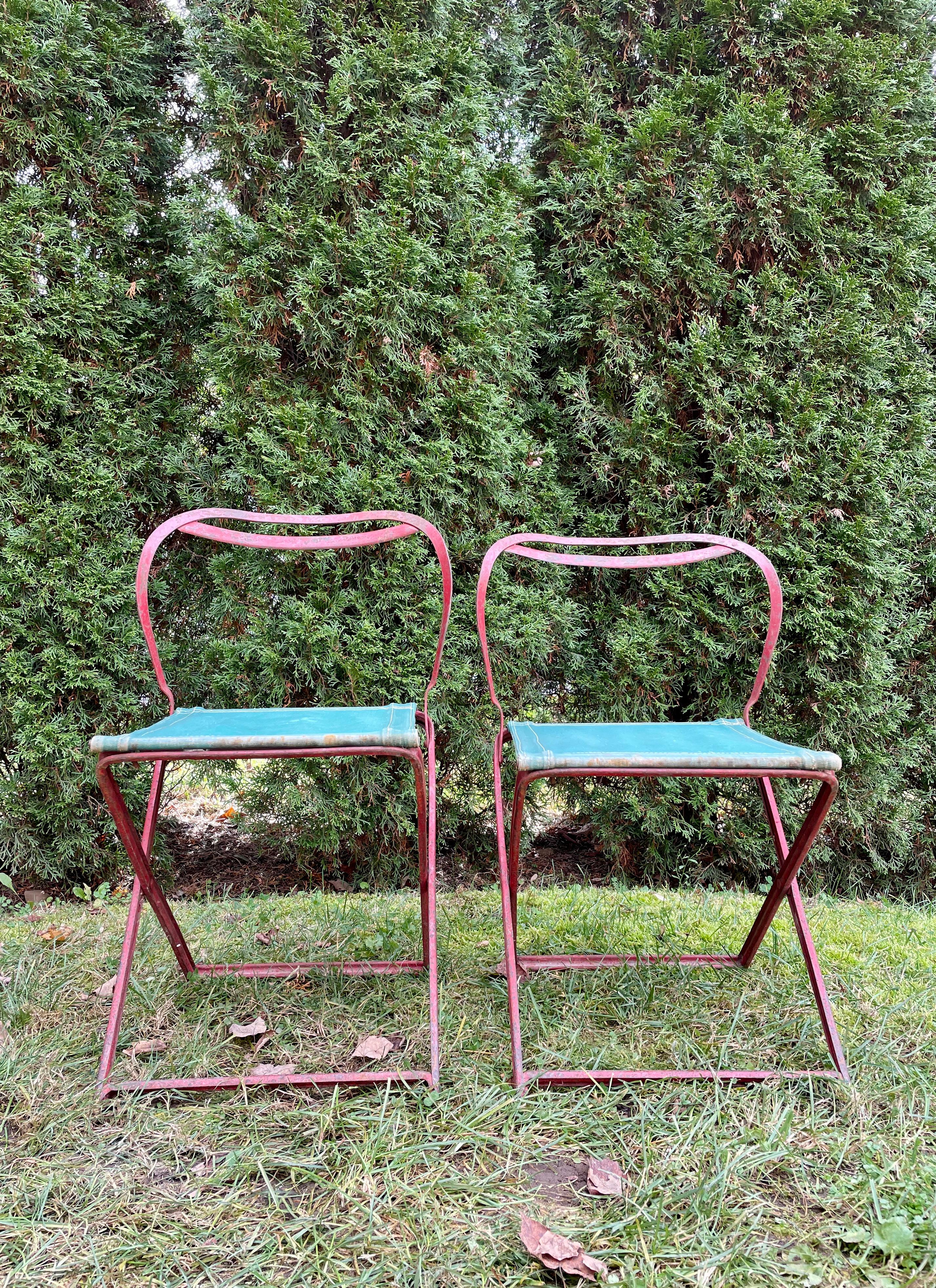 Never in all our decades of dealing have we seen chairs like these! Clearly French Deco and featuring older (possibly original) green canvas seats, these red-painted wrought iron chairs fold in three positions including a stool configuration.