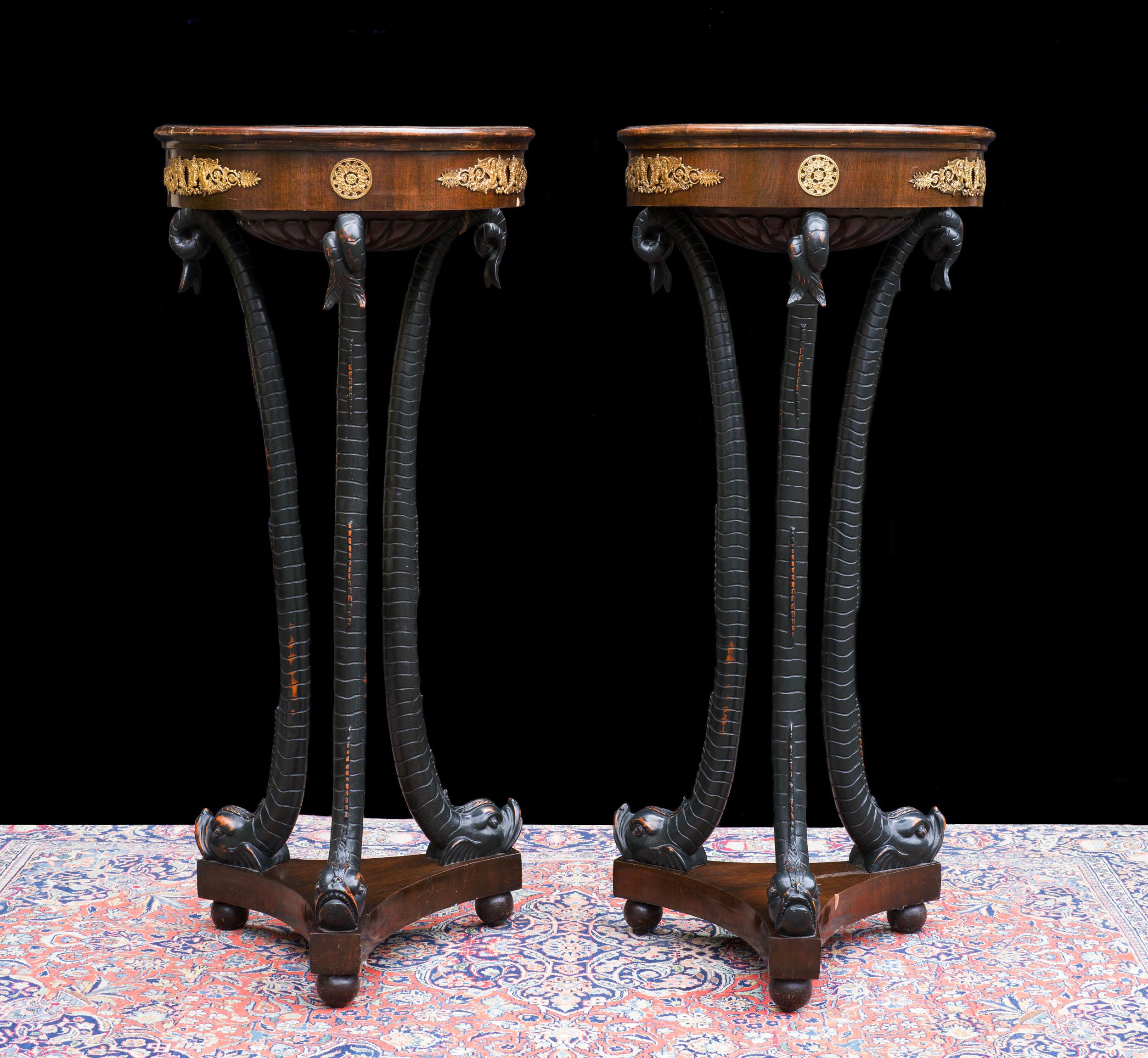 Ein seltenes Paar französischer Fackeltische oder Gueridon-Tische, mit eingelassenen Marmorplatten über einer ormolierten, furnierten Platte, über einem dreiförmigen Sockel, der Beine trägt, die als Delphine im römischen Stil modelliert sind, mit